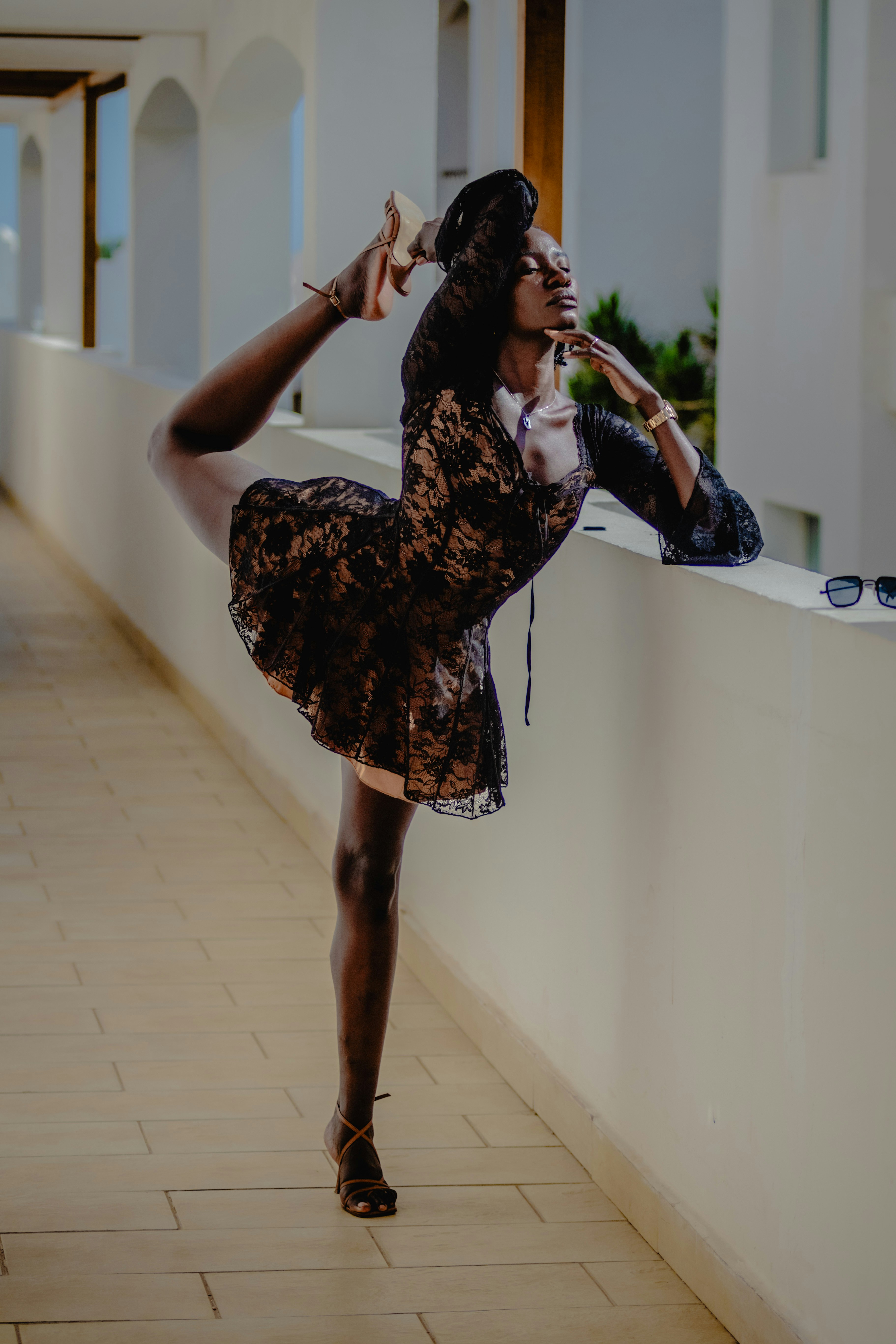 A woman in a dress is leaning against a wall