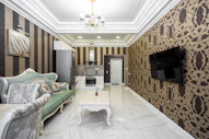 A living room with couches and a TV on a wall