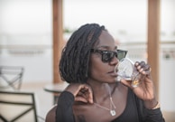 A woman drinking a glass of wine at a table