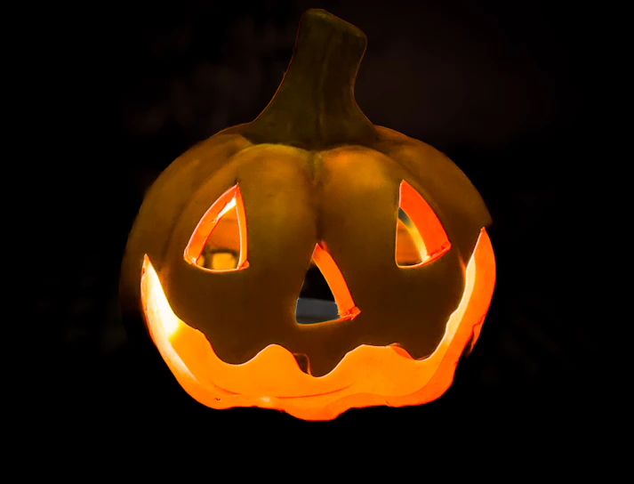 A lit up jack o lantern in the dark