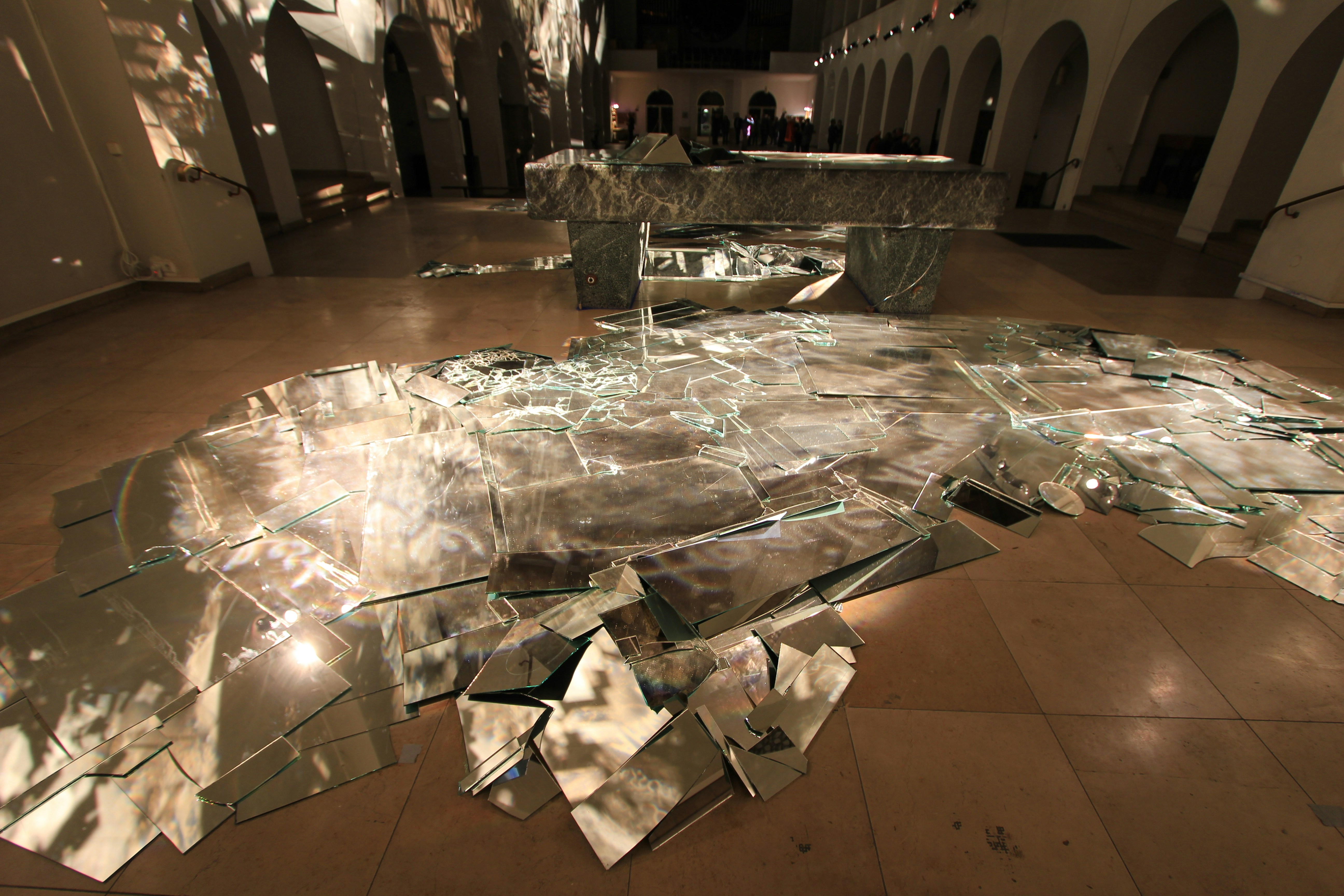 A broken mirror on the floor of a building