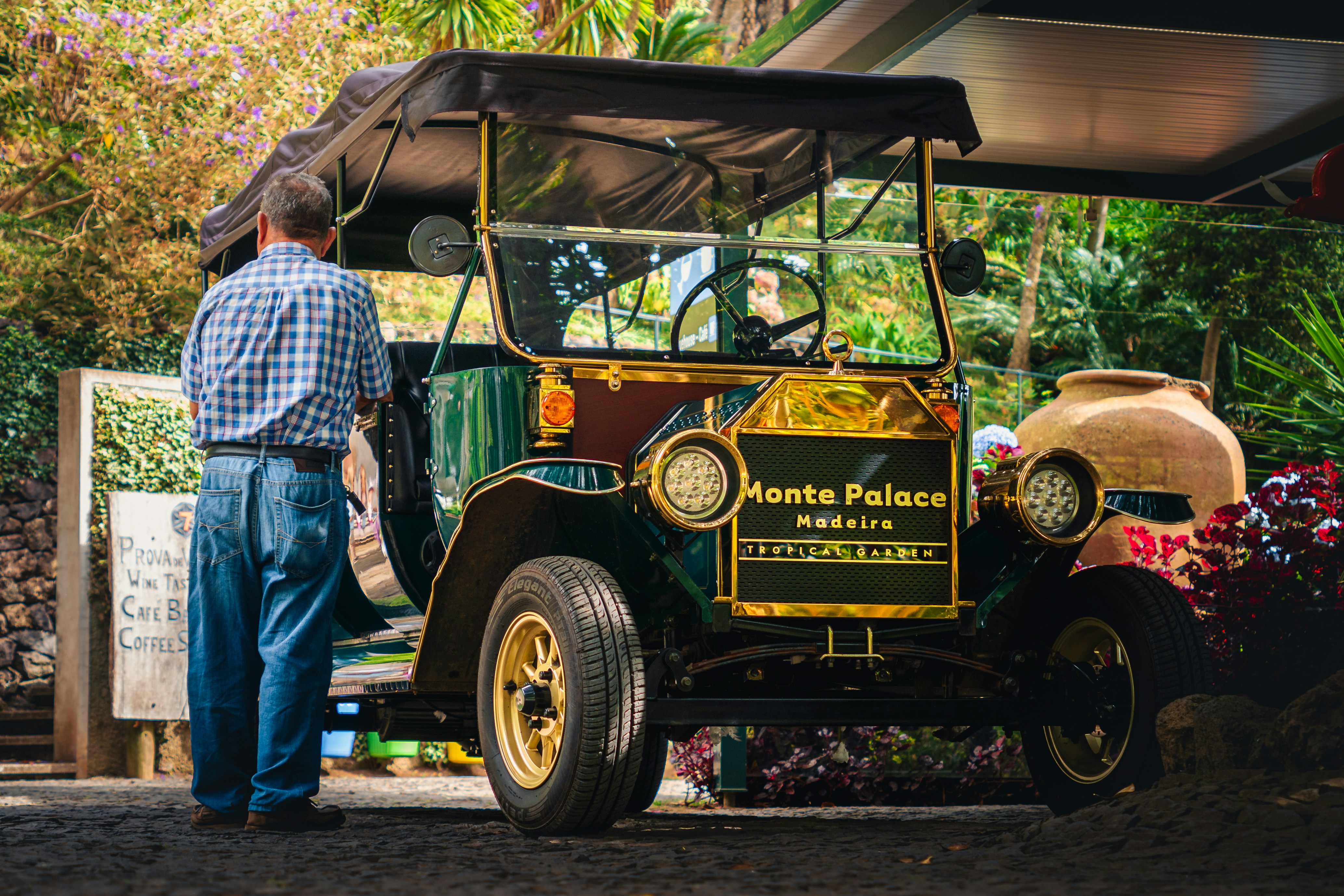 A man standing next to an old fashioned car