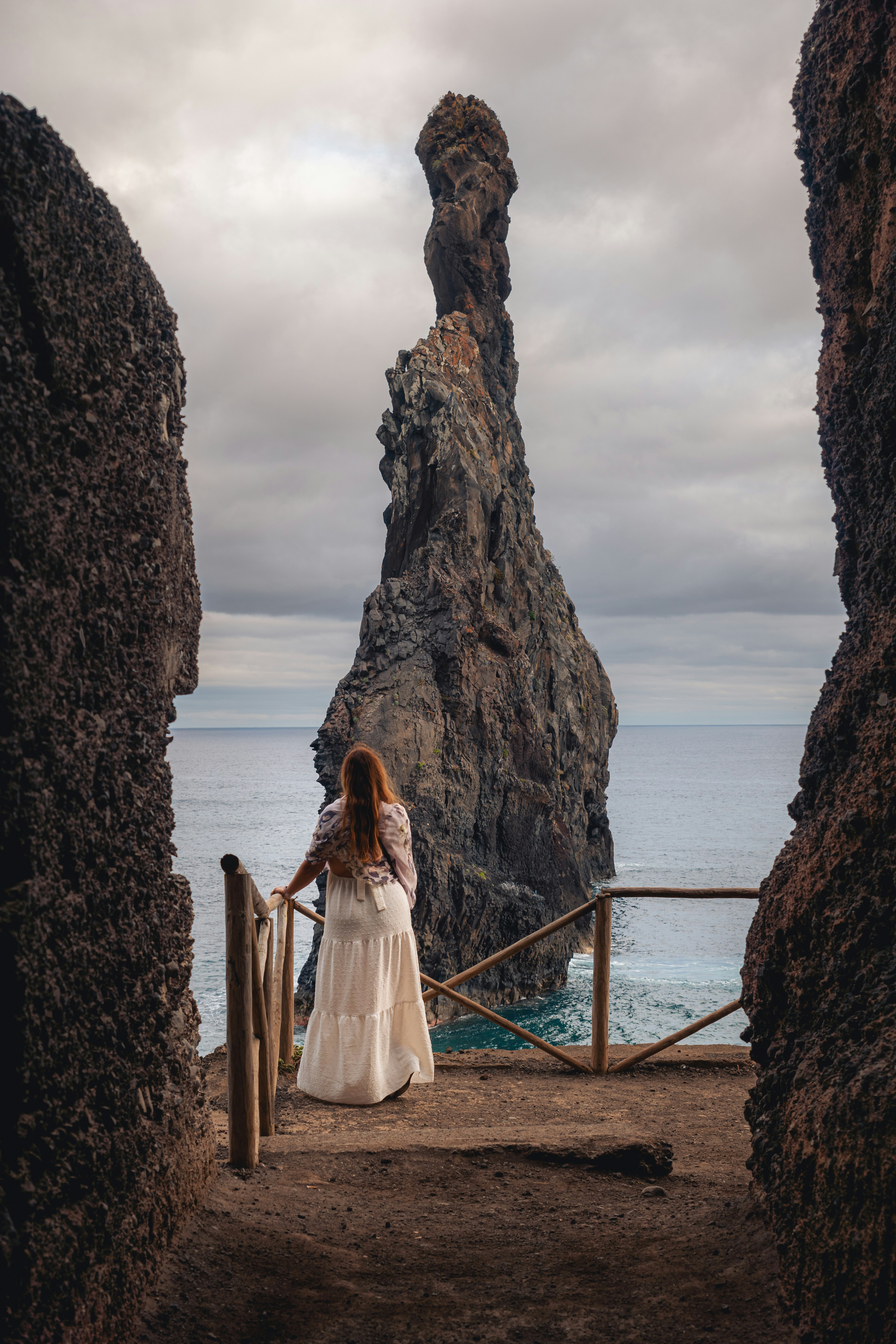 Una mujer con un vestido blanco está de pie en un puente