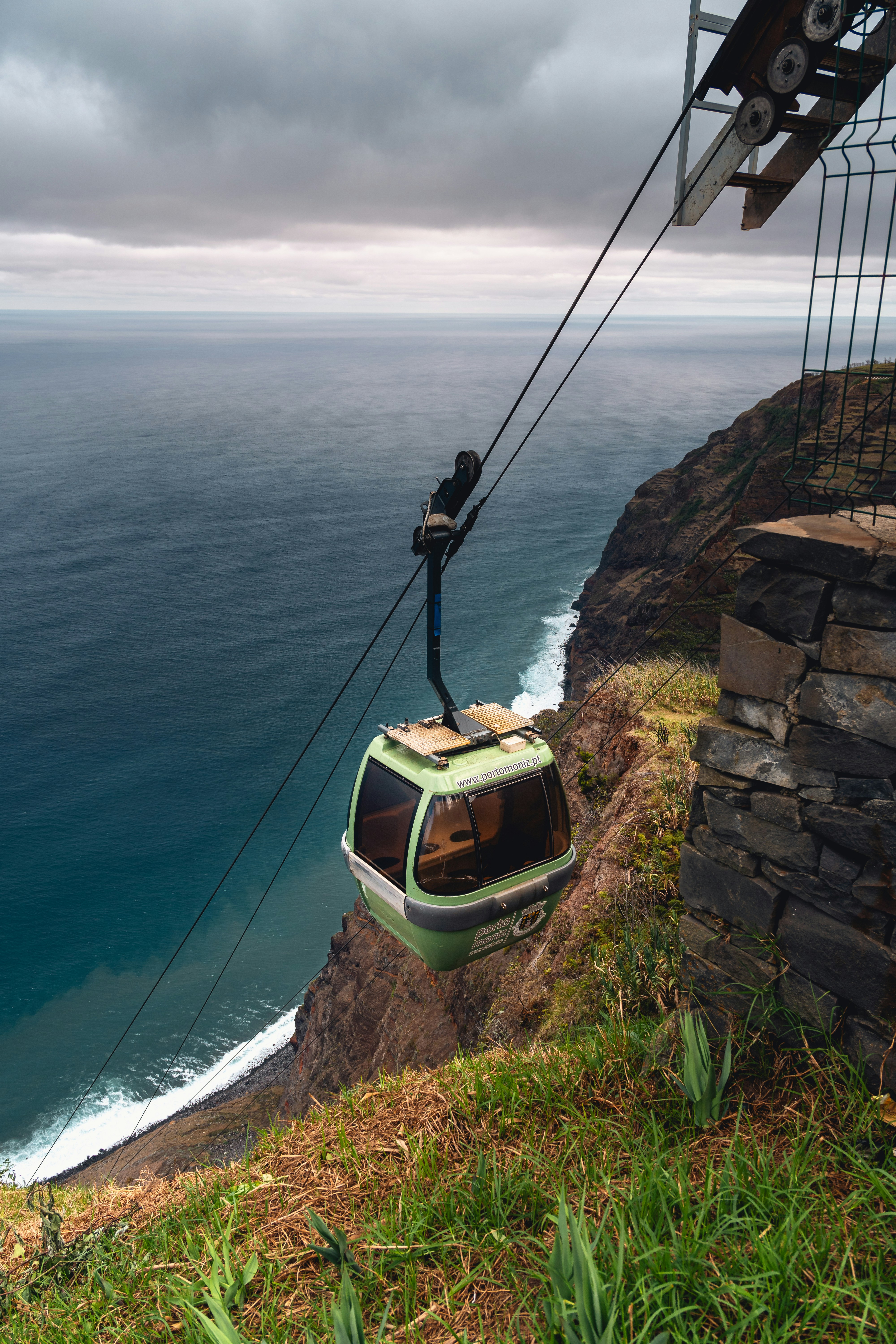 Un teleférico suspendido sobre un acantilado junto al océano