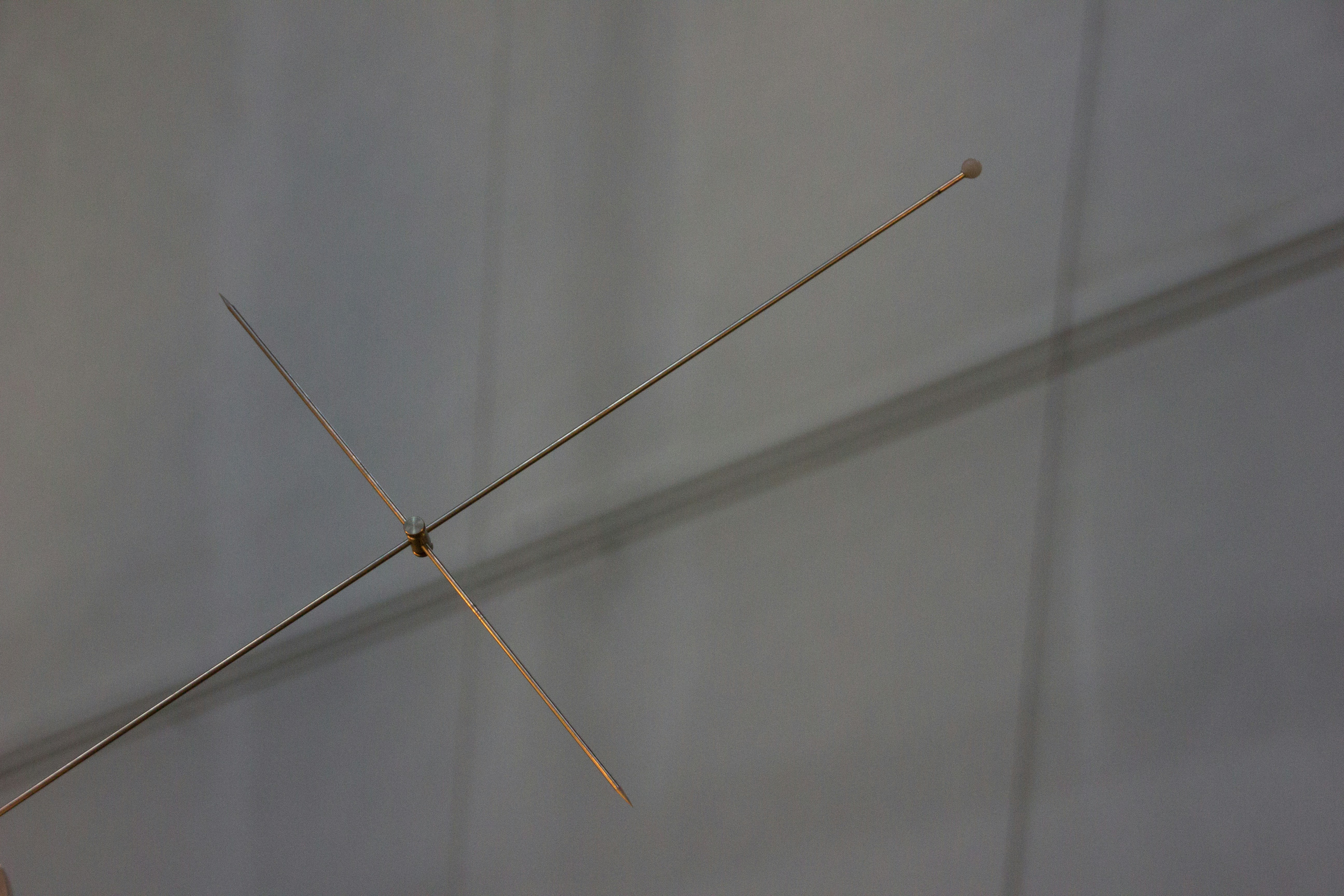 A pair of needles sticking out of the side of a wall