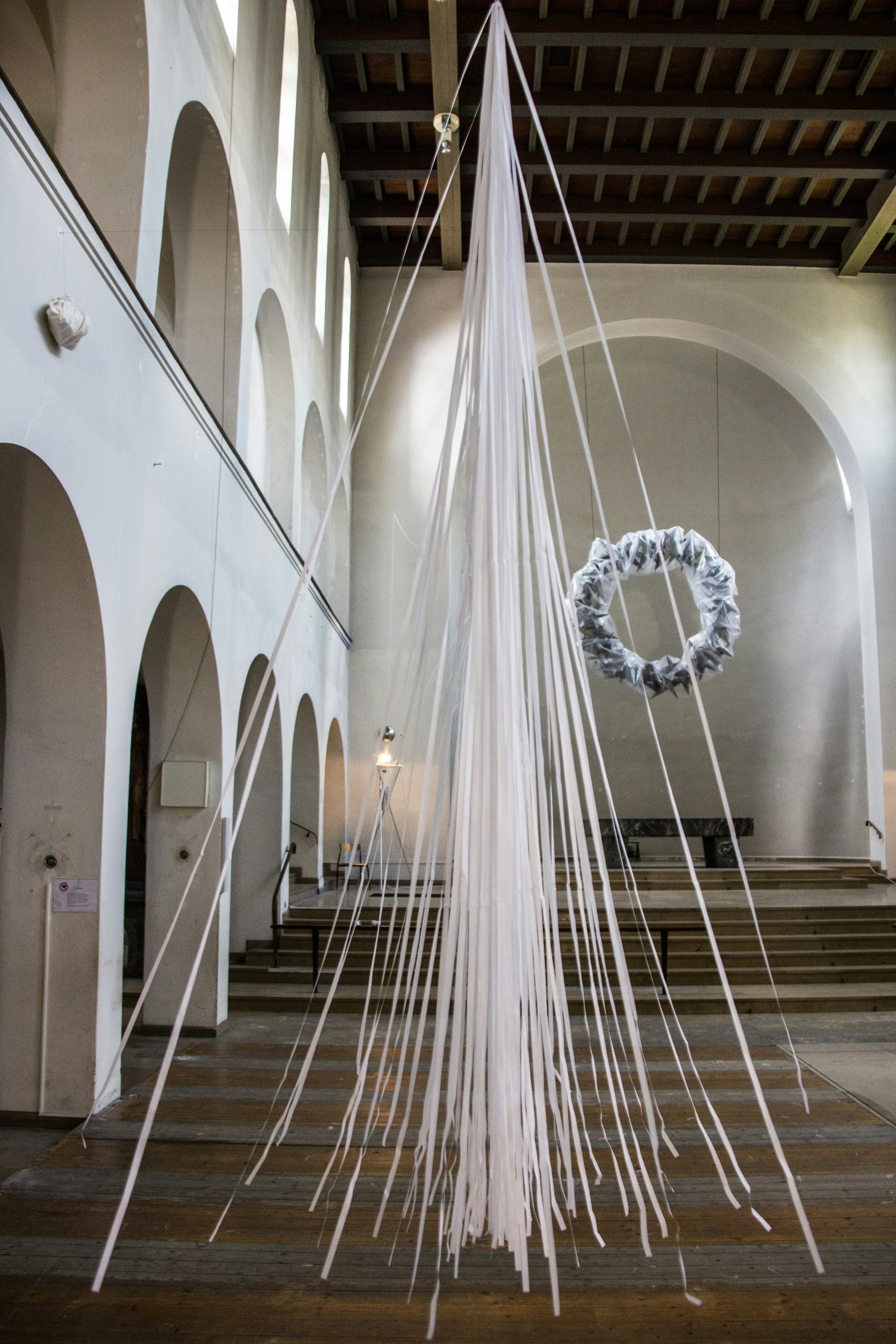 A room with a bunch of white strings hanging from the ceiling