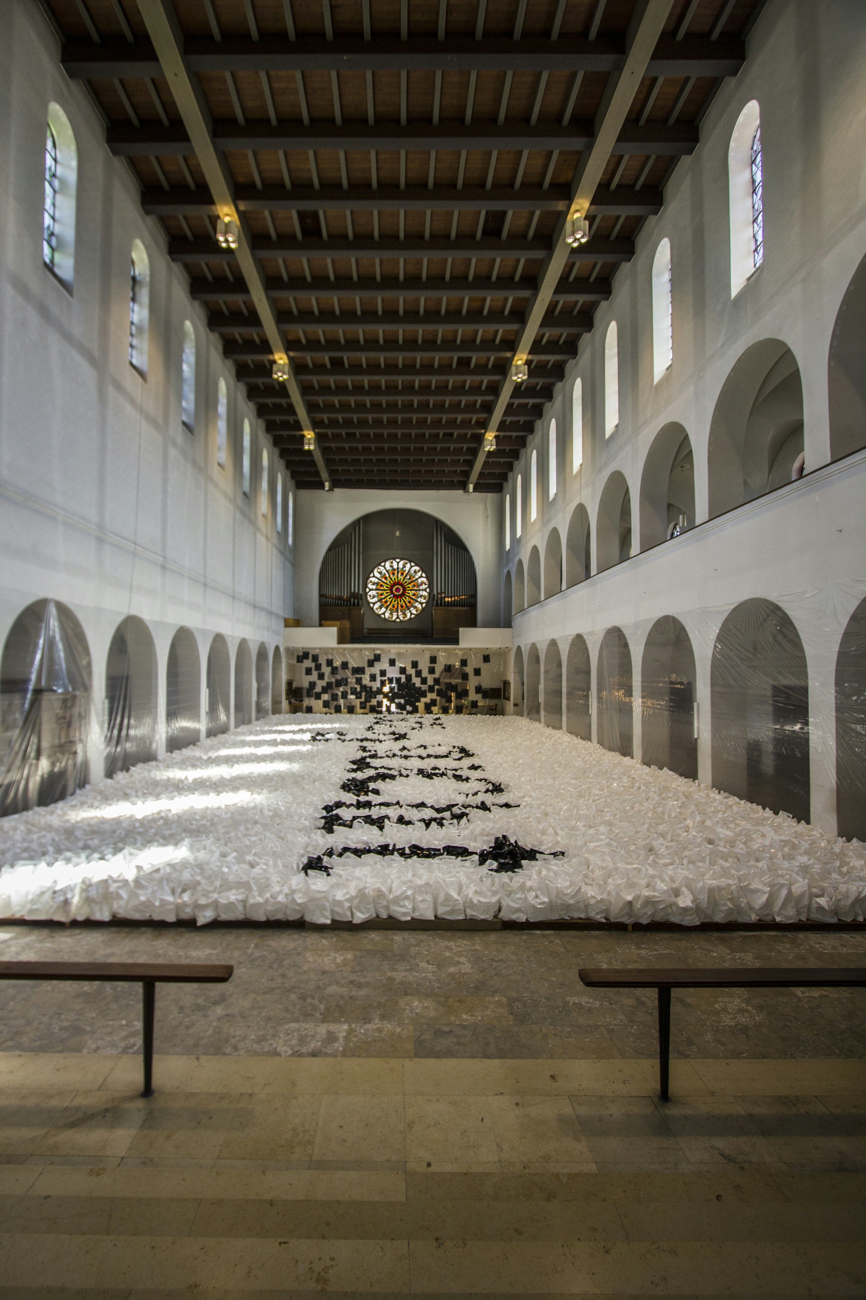 A large room with benches and a painting on the wall
