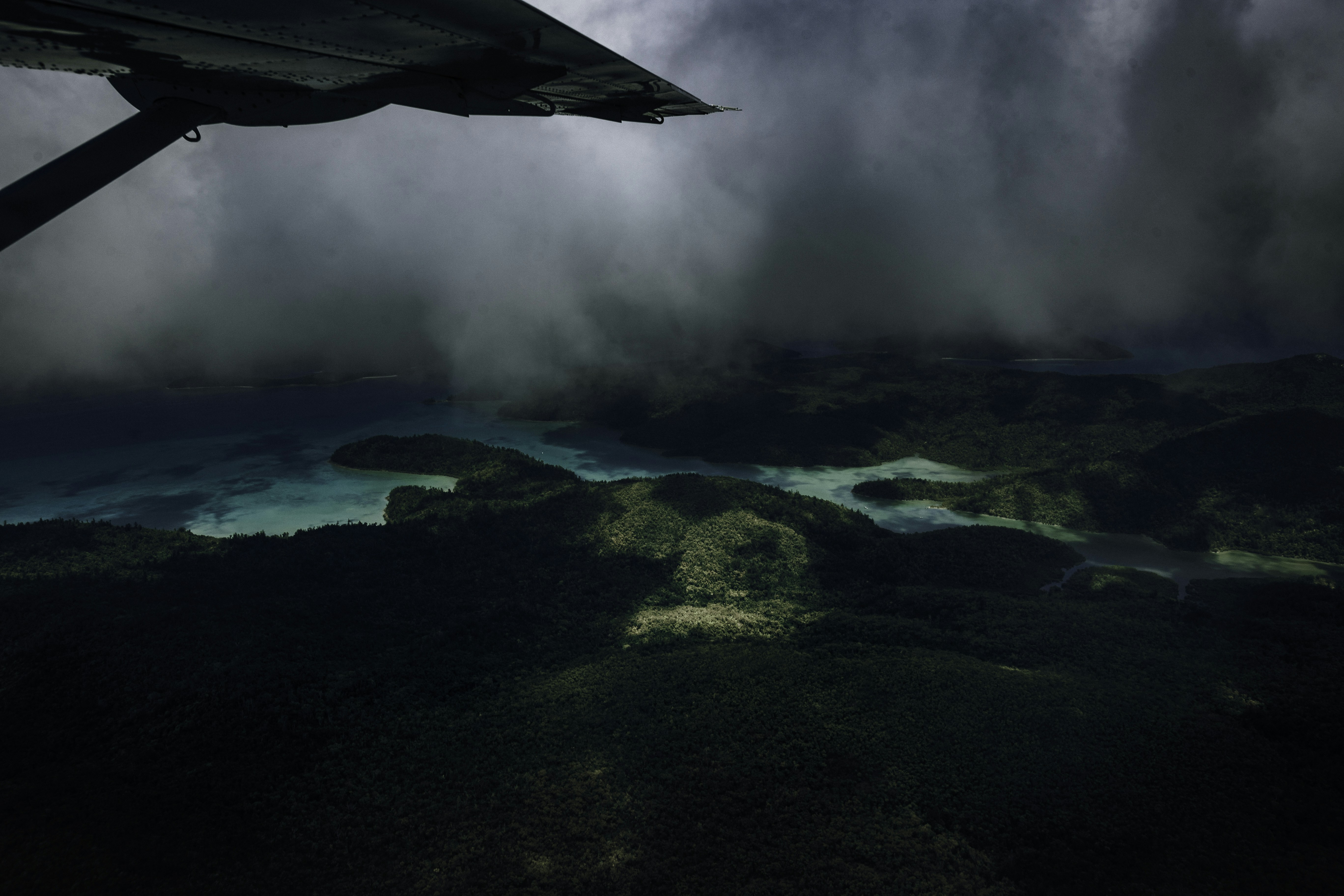 Aerial view of island terrain with dramatic lighting and clouds, action-packed environmental scene
