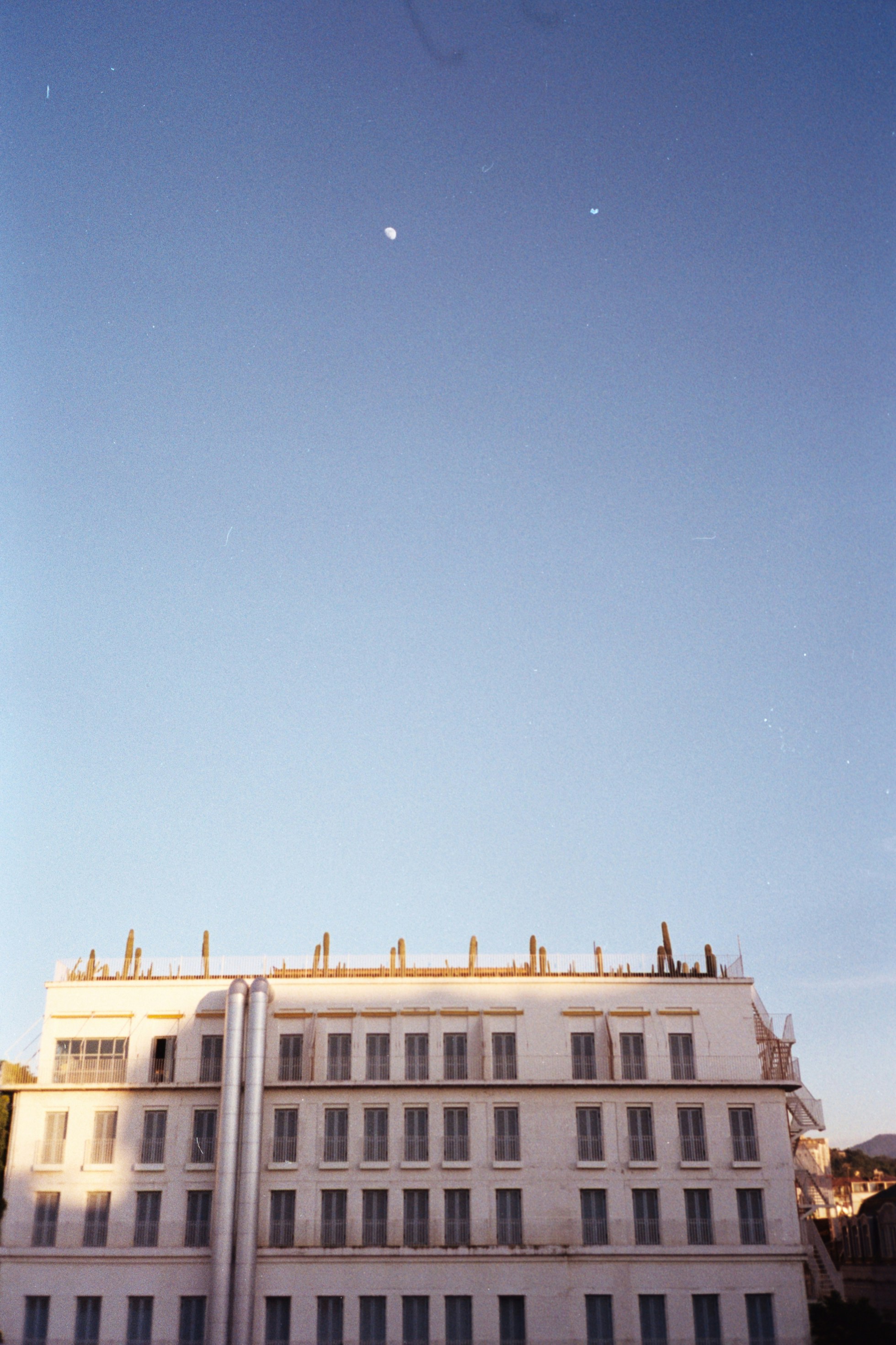 A tall white building with a sky background