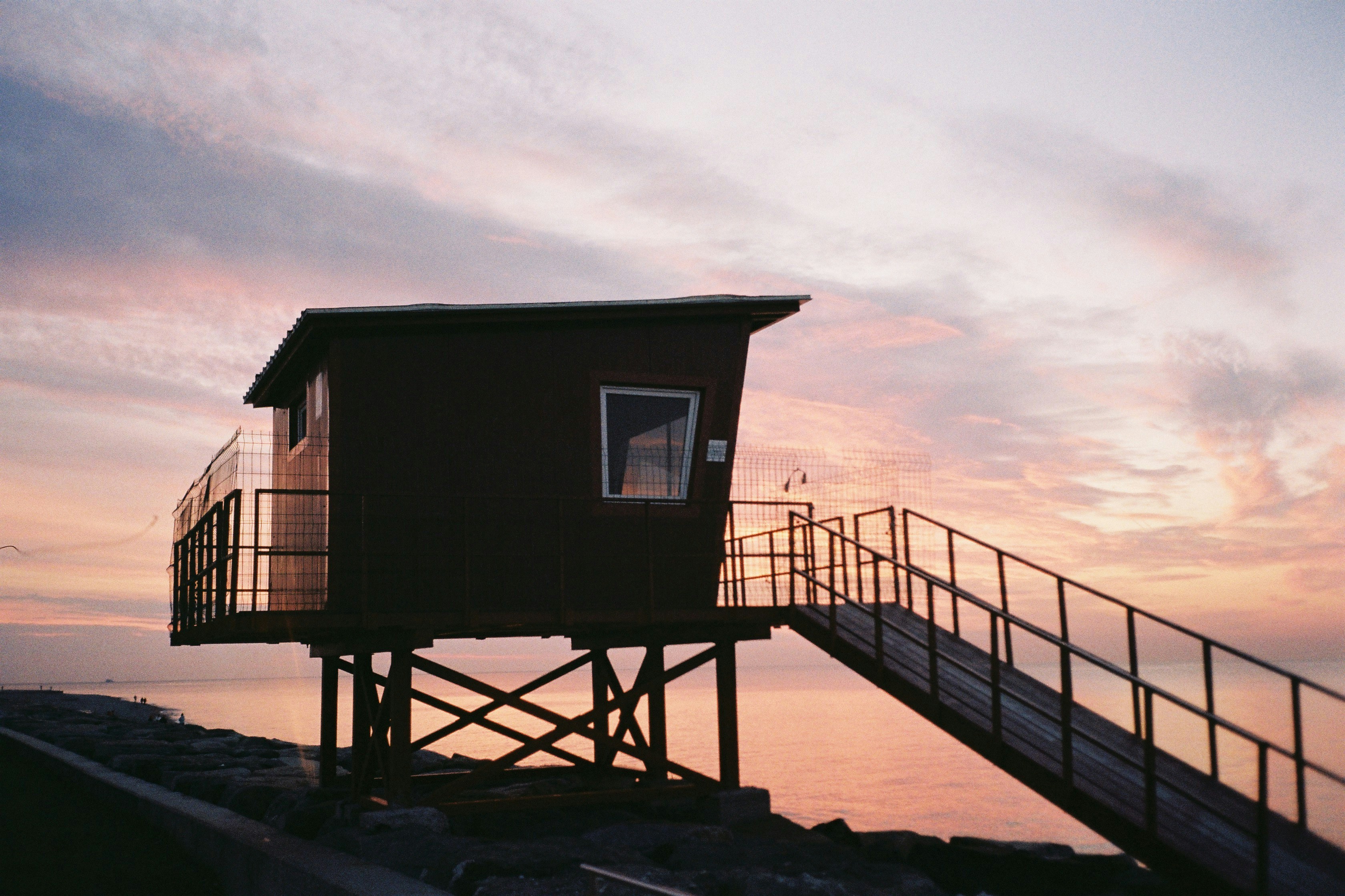 A lifeguard tower sitting on top of a beach next to the ocean