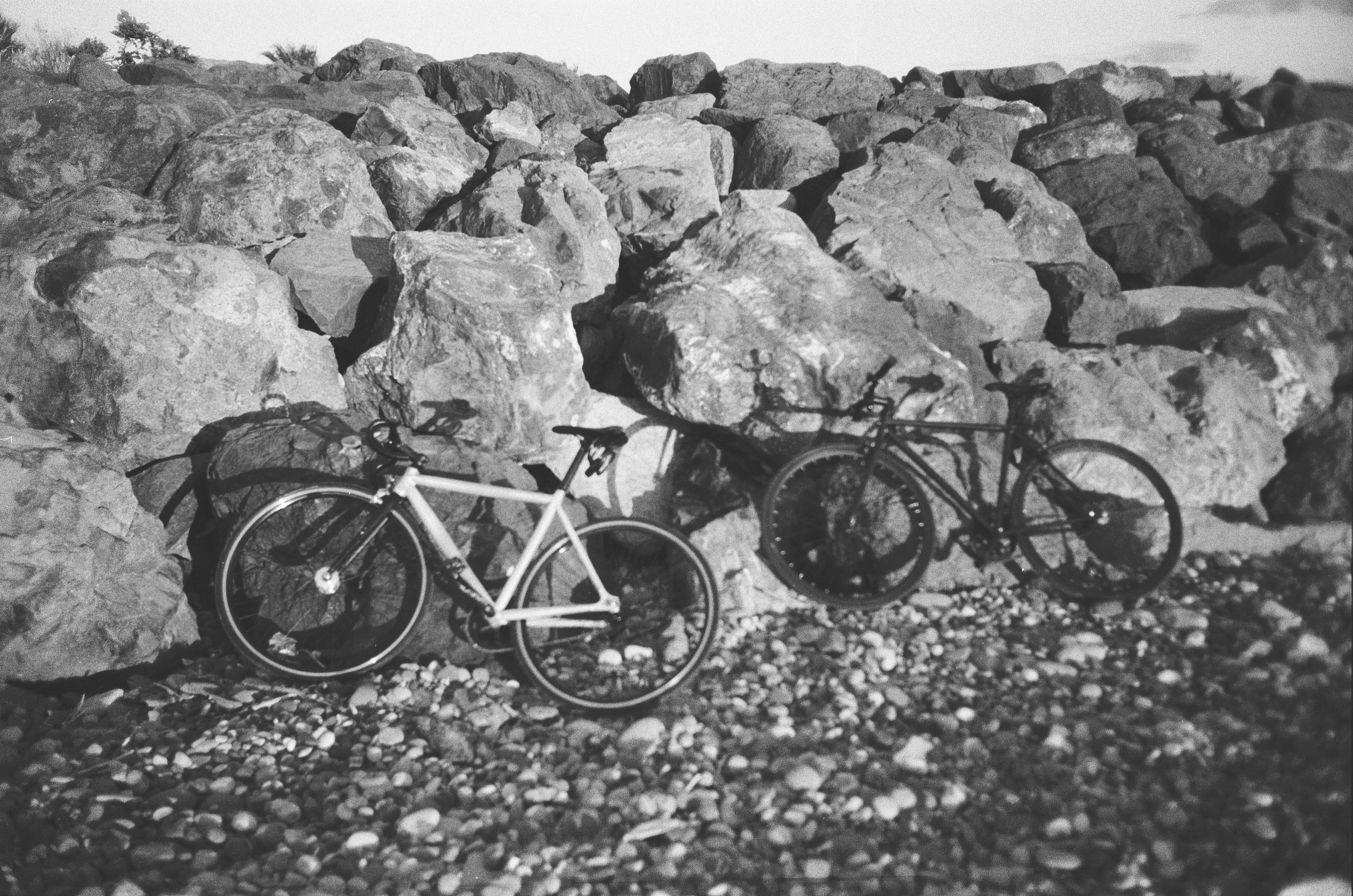 A couple of bikes parked next to a pile of rocks
