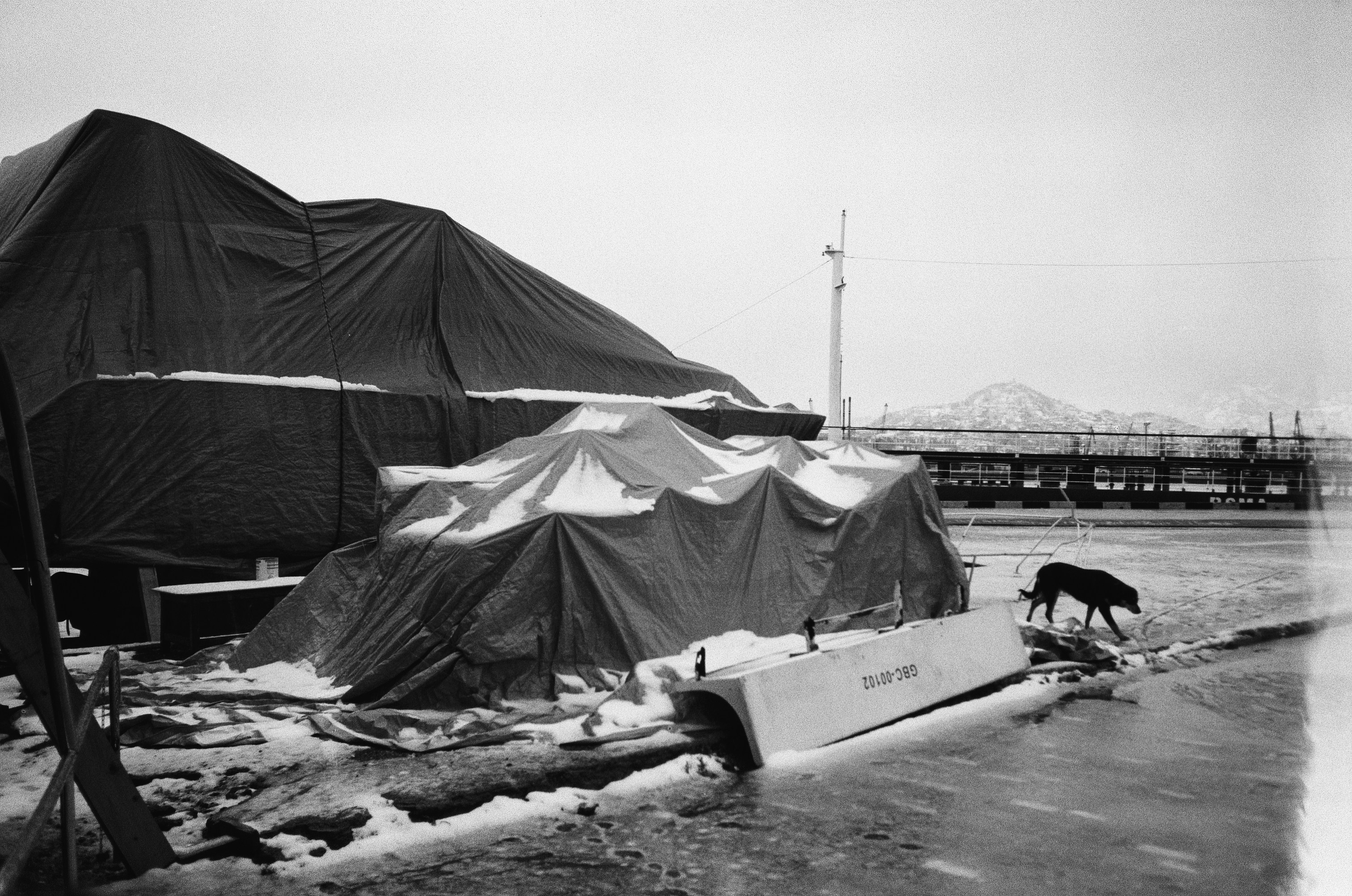 A black and white photo of a boat and a tent