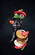 A statue of a black cat with a hamburger in its mouth