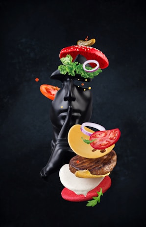 A statue of a black cat with a hamburger in its mouth