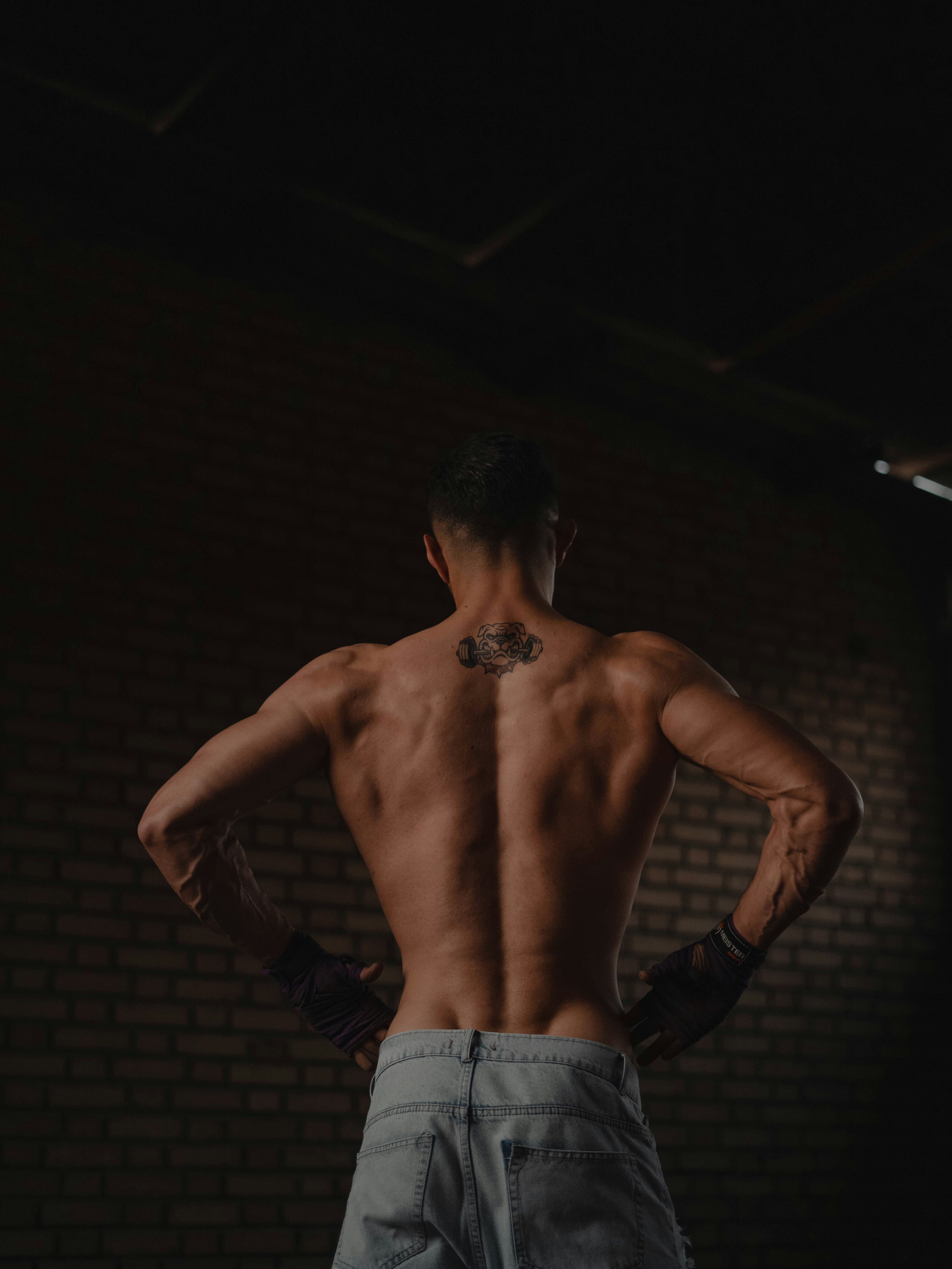 A man standing in a dark room with his back to the camera