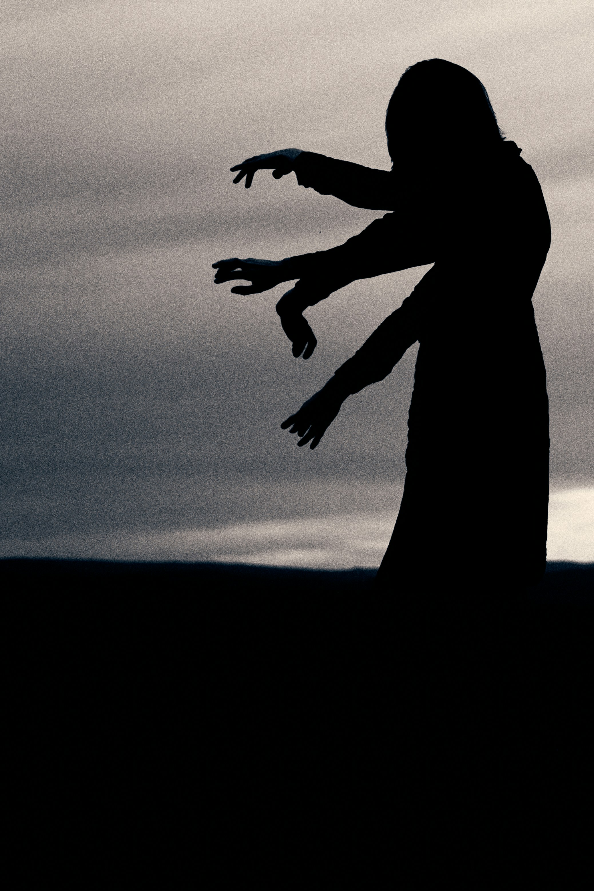 A silhouette of a person throwing a frisbee