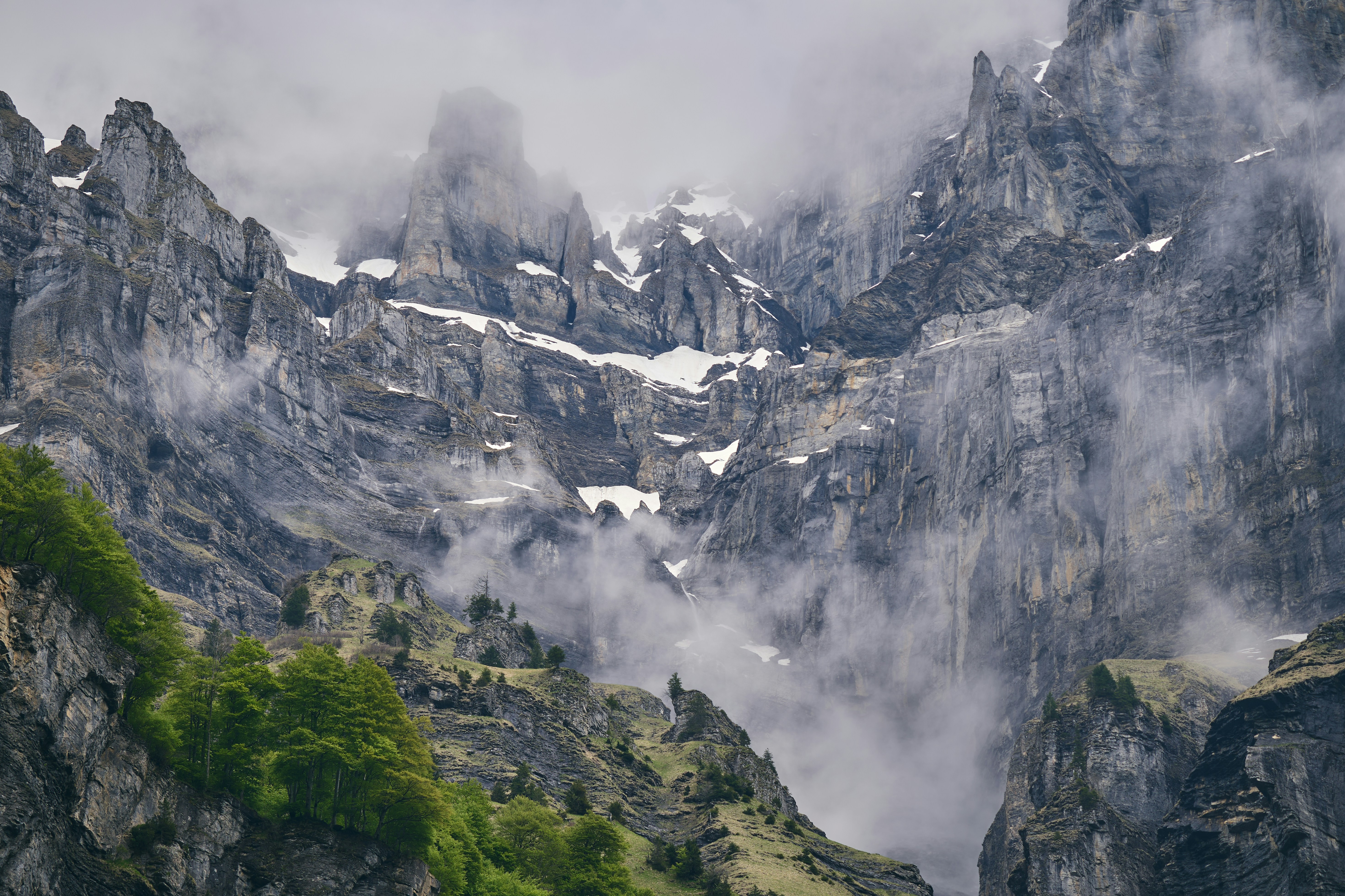 A mountain range covered in snow and clouds