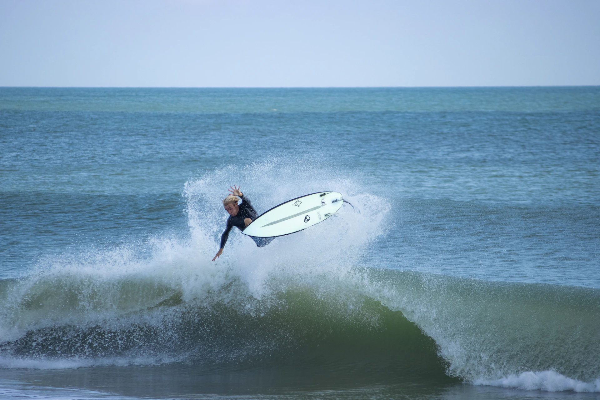 A man riding a wave on top of a surfboard
