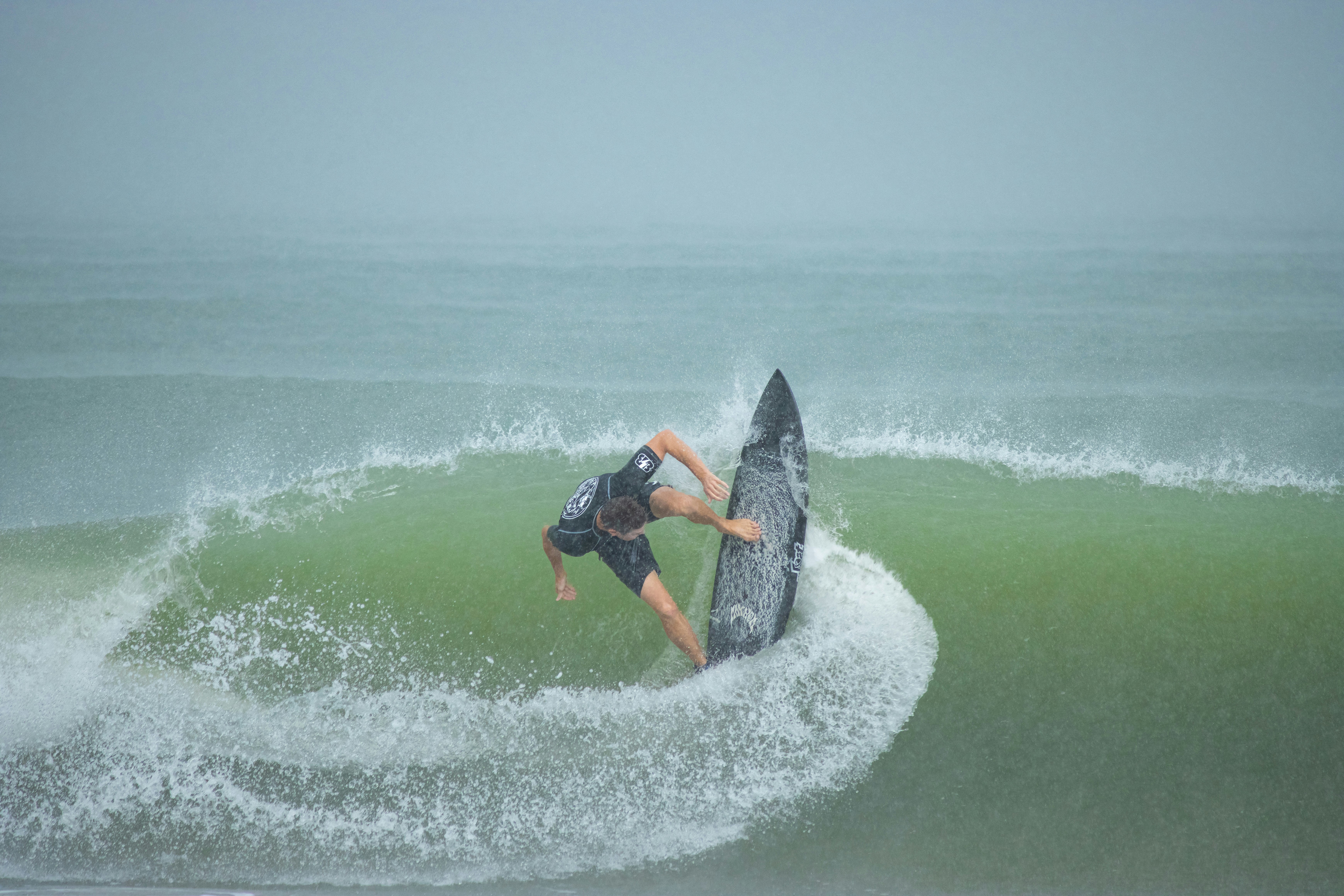 Ein Mann reitet auf einer Welle auf einem Surfbrett