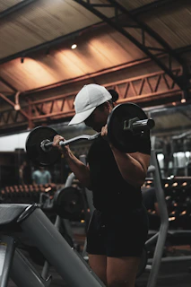 A woman lifting a barbell in a gym