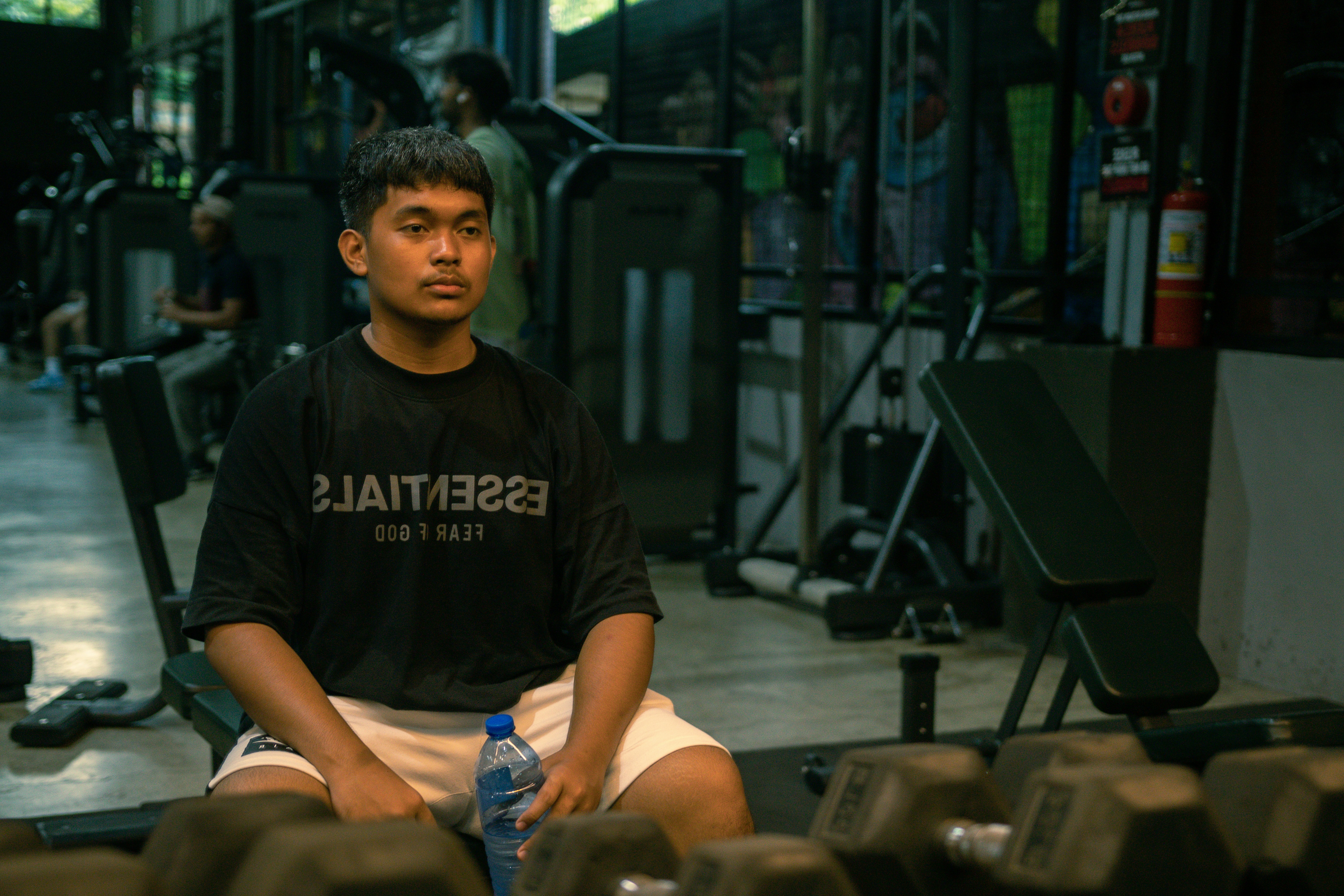 A man sitting on a bench in a gym