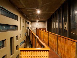 A long hallway with wooden railings and windows