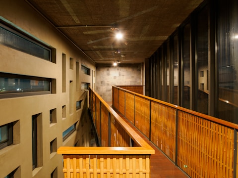 A long hallway with wooden railings and windows