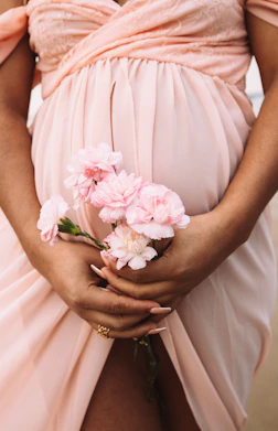 A pregnant woman holding a bouquet of flowers