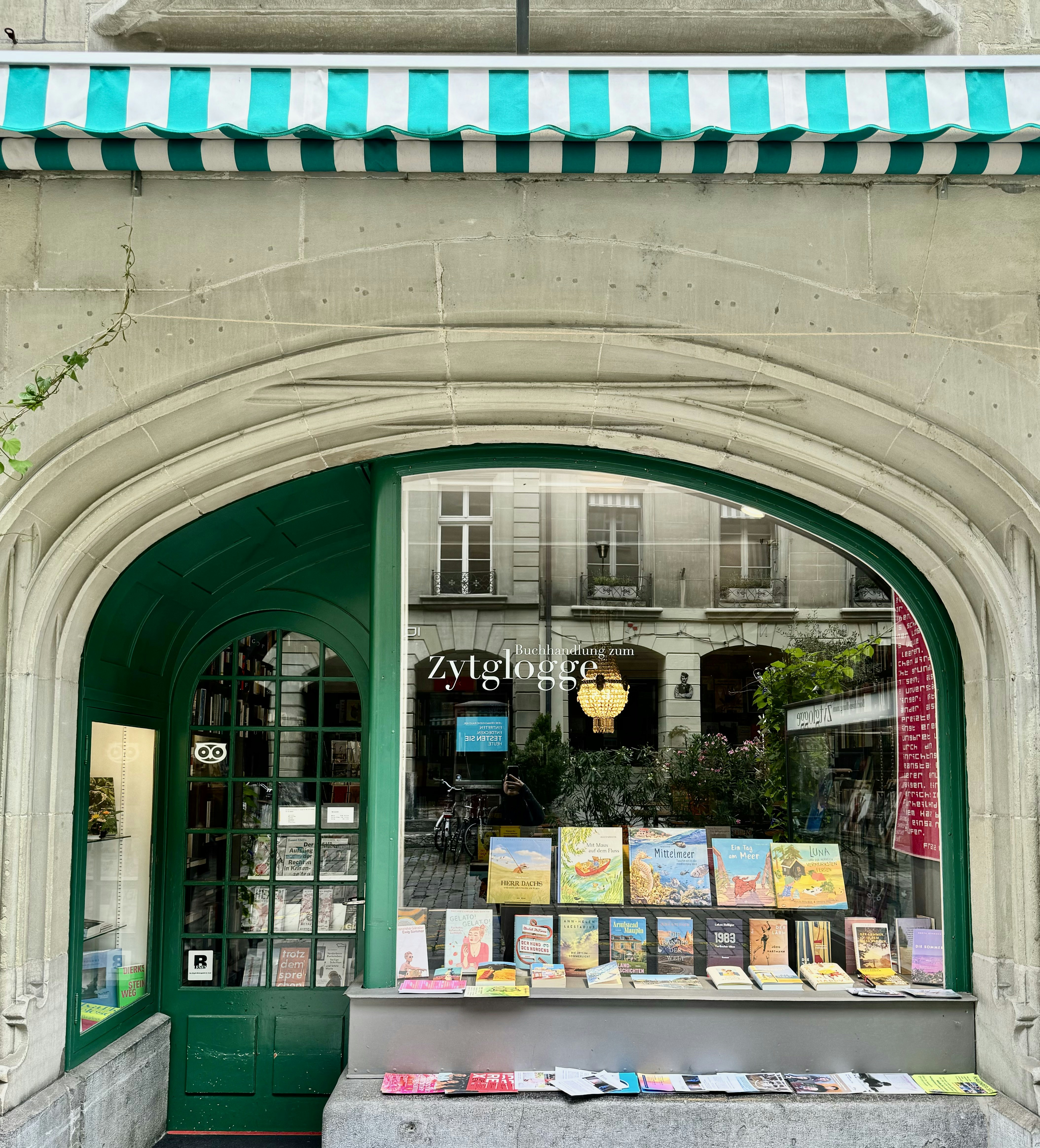 Un edificio con una puerta verde y un toldo verde y blanco