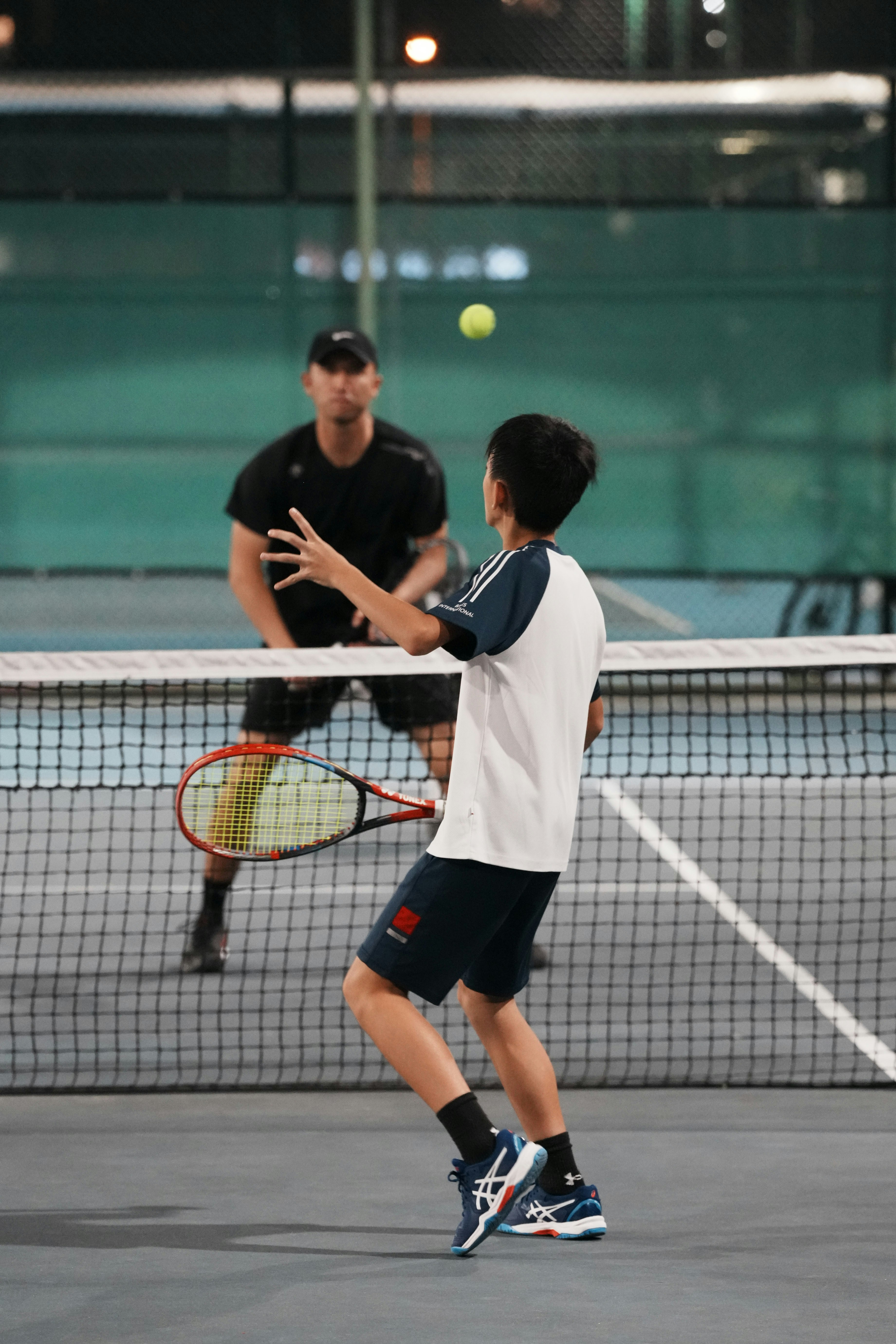 Two men playing tennis on a tennis court