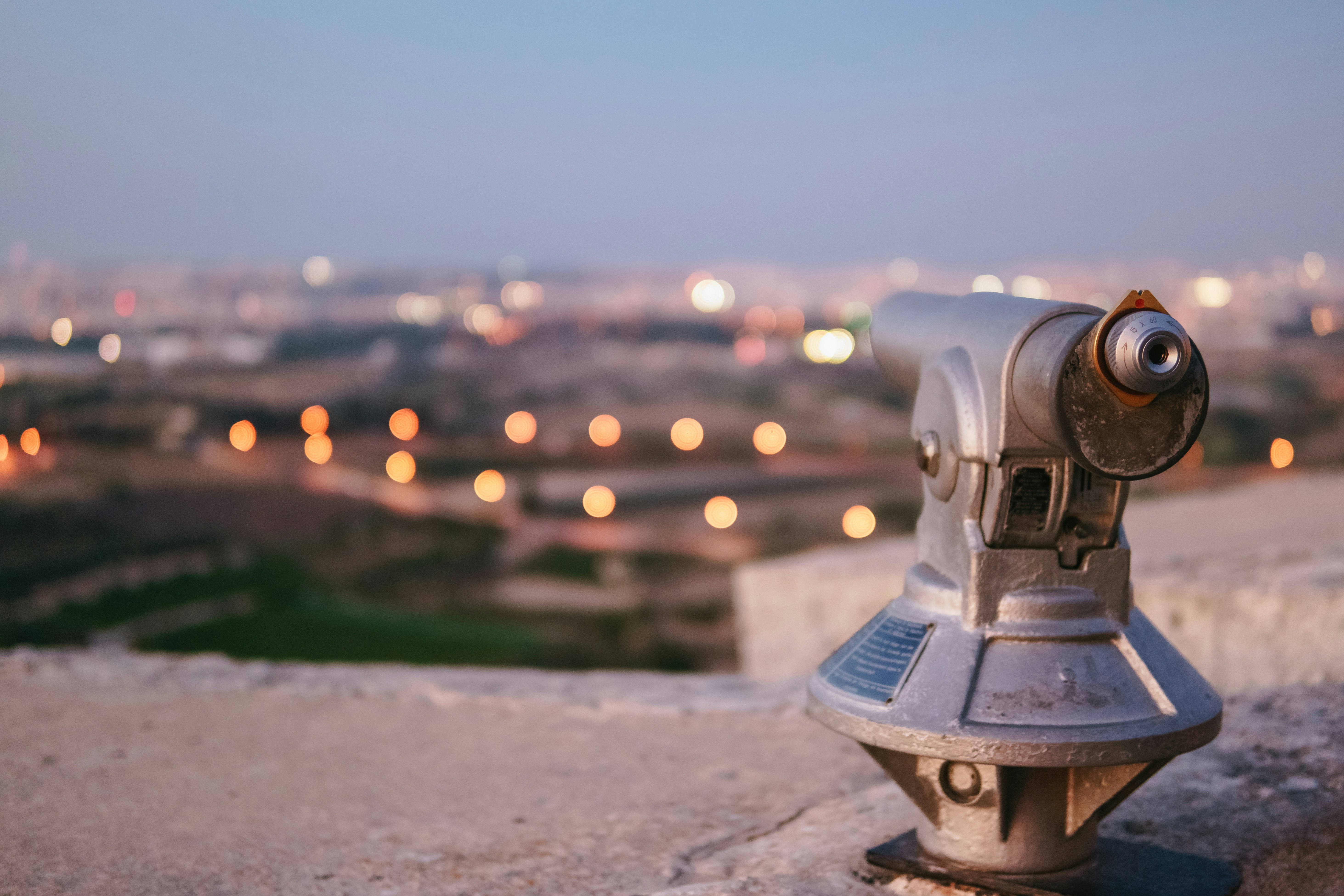 A close up of a coin operated binoculars on a ledge