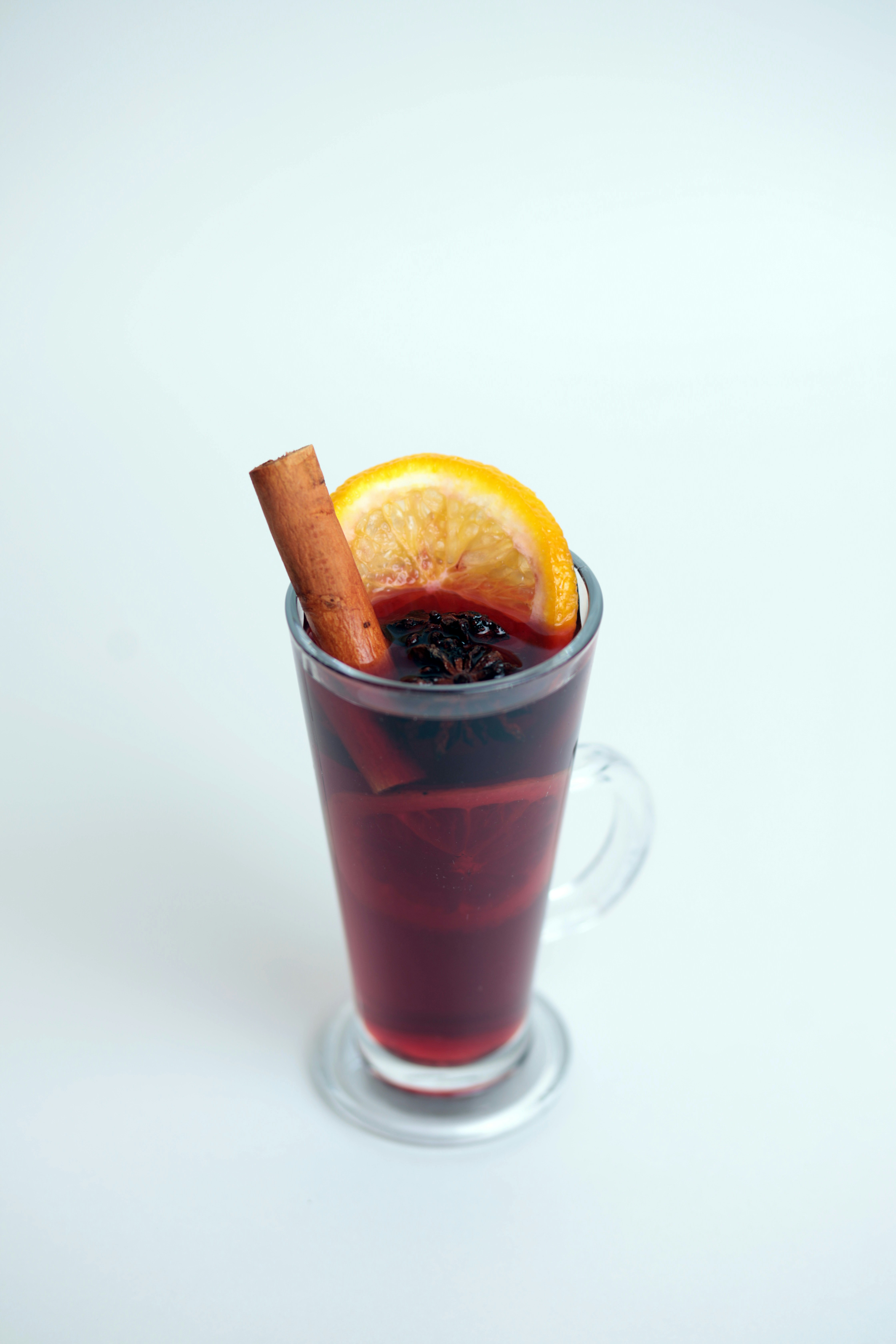 A glass of mulled with a cinnamon stick sticking out of it