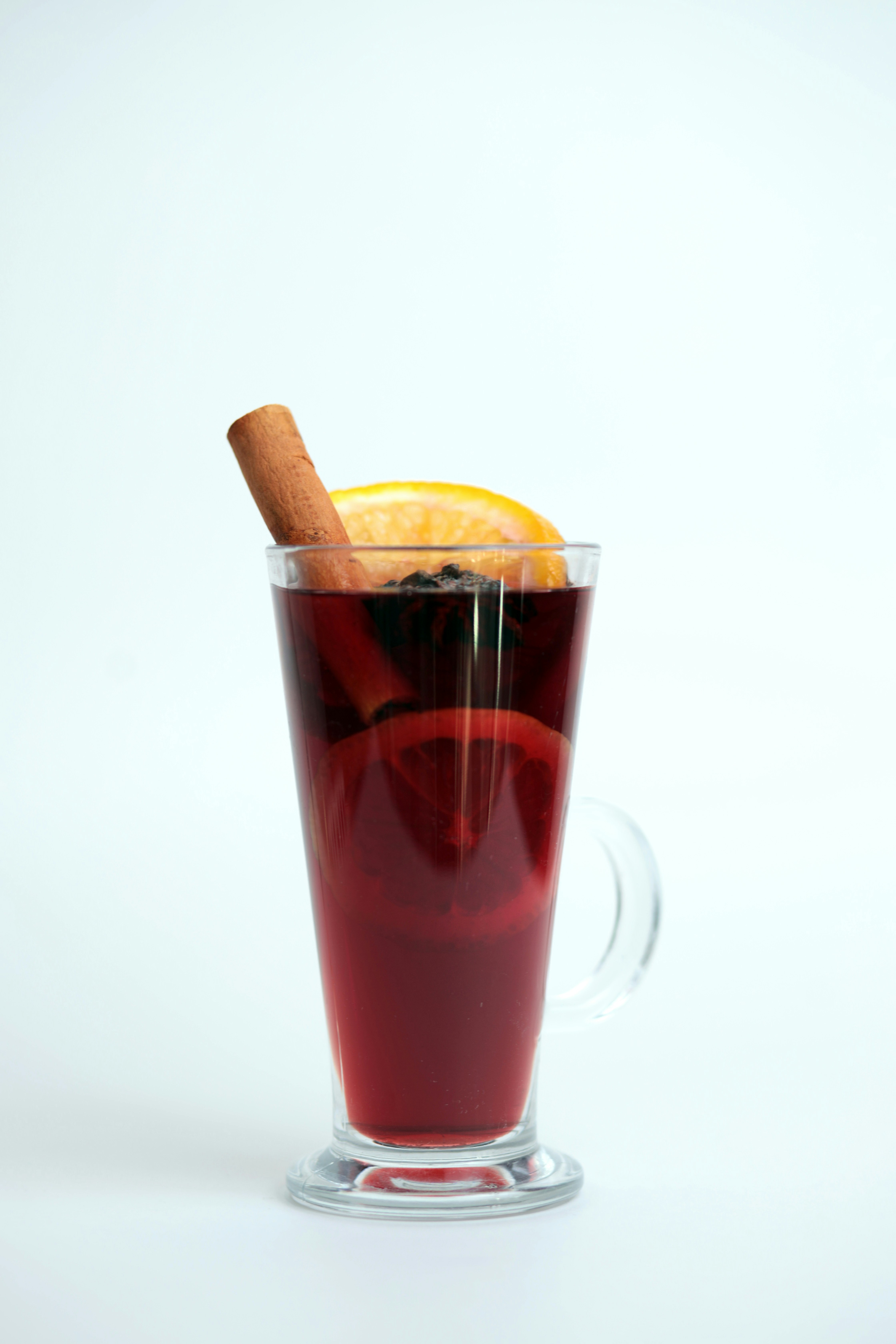 A glass of mulled with a cinnamon stick sticking out of it