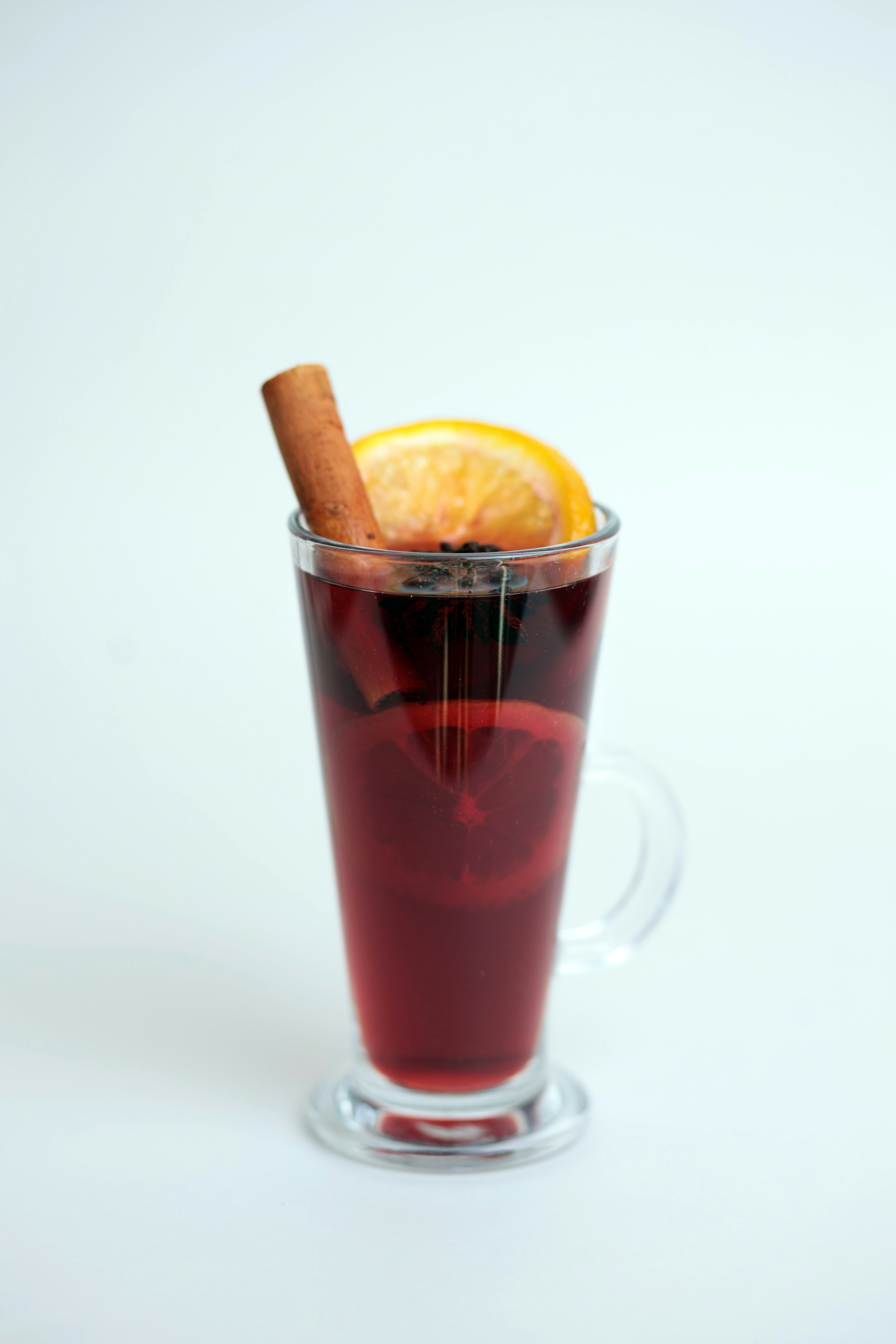 A glass of mulled with a cinnamon stick sticking out of it