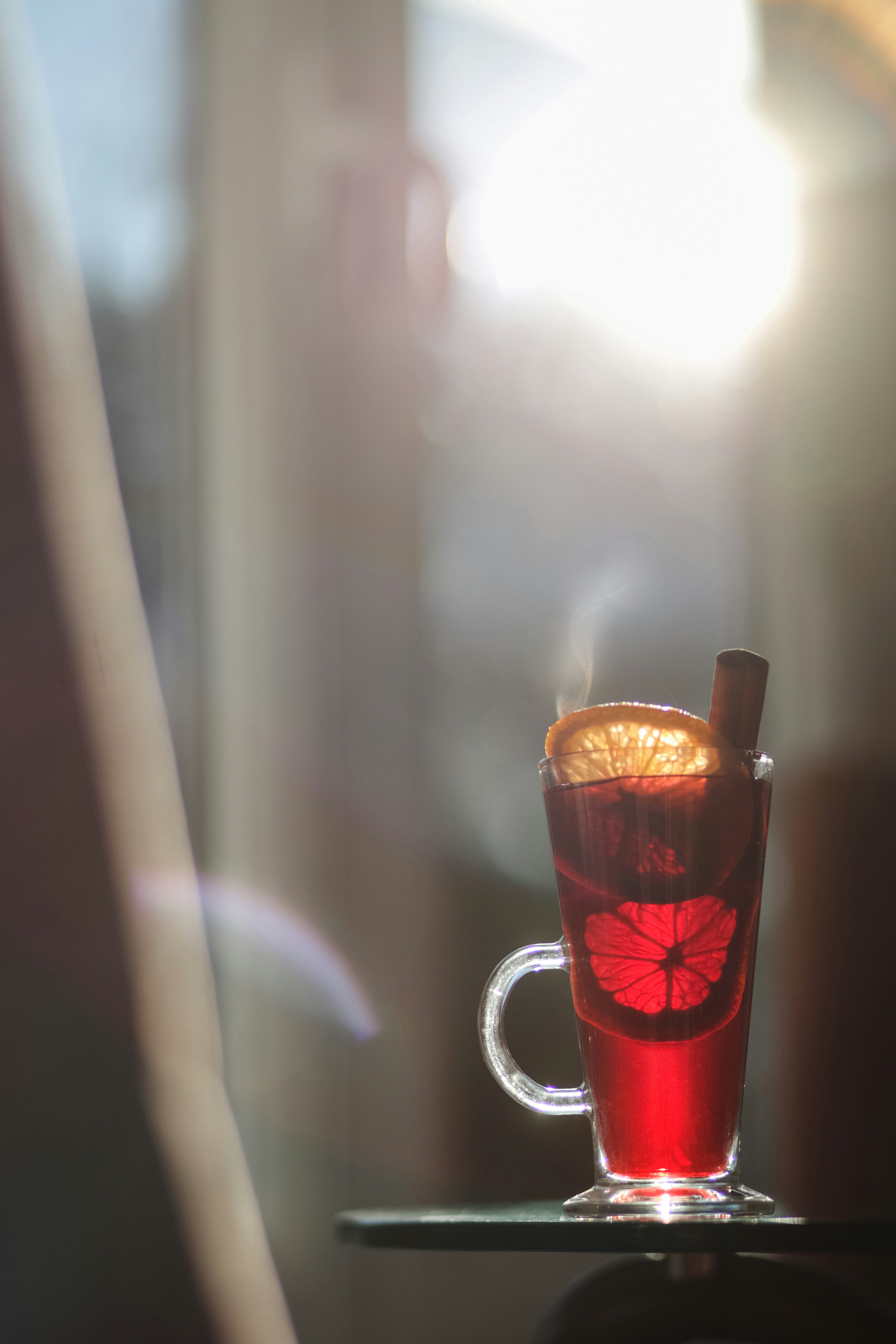 A red drink sitting on top of a table next to a window