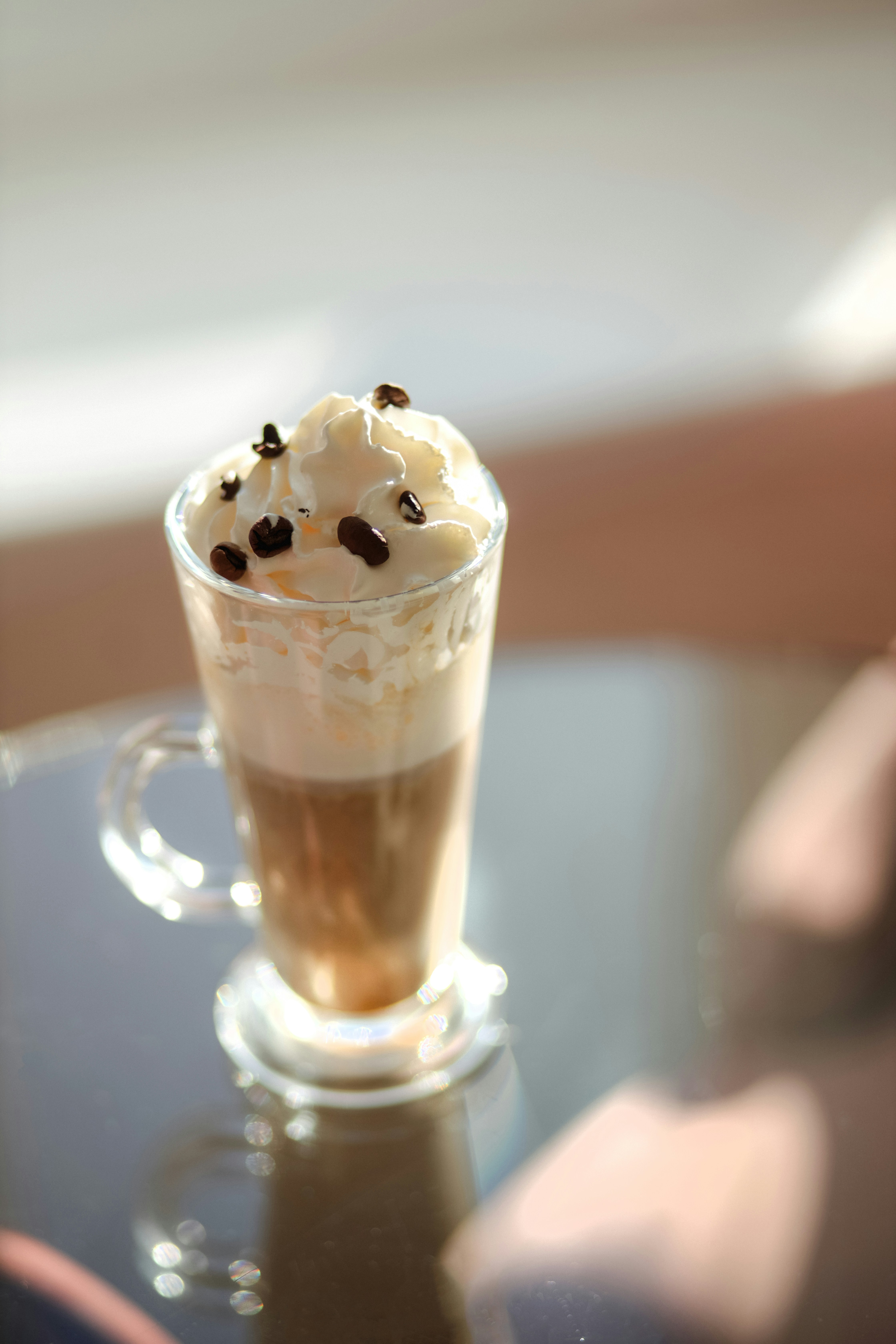 A cup of coffee with whipped cream and chocolate chips
