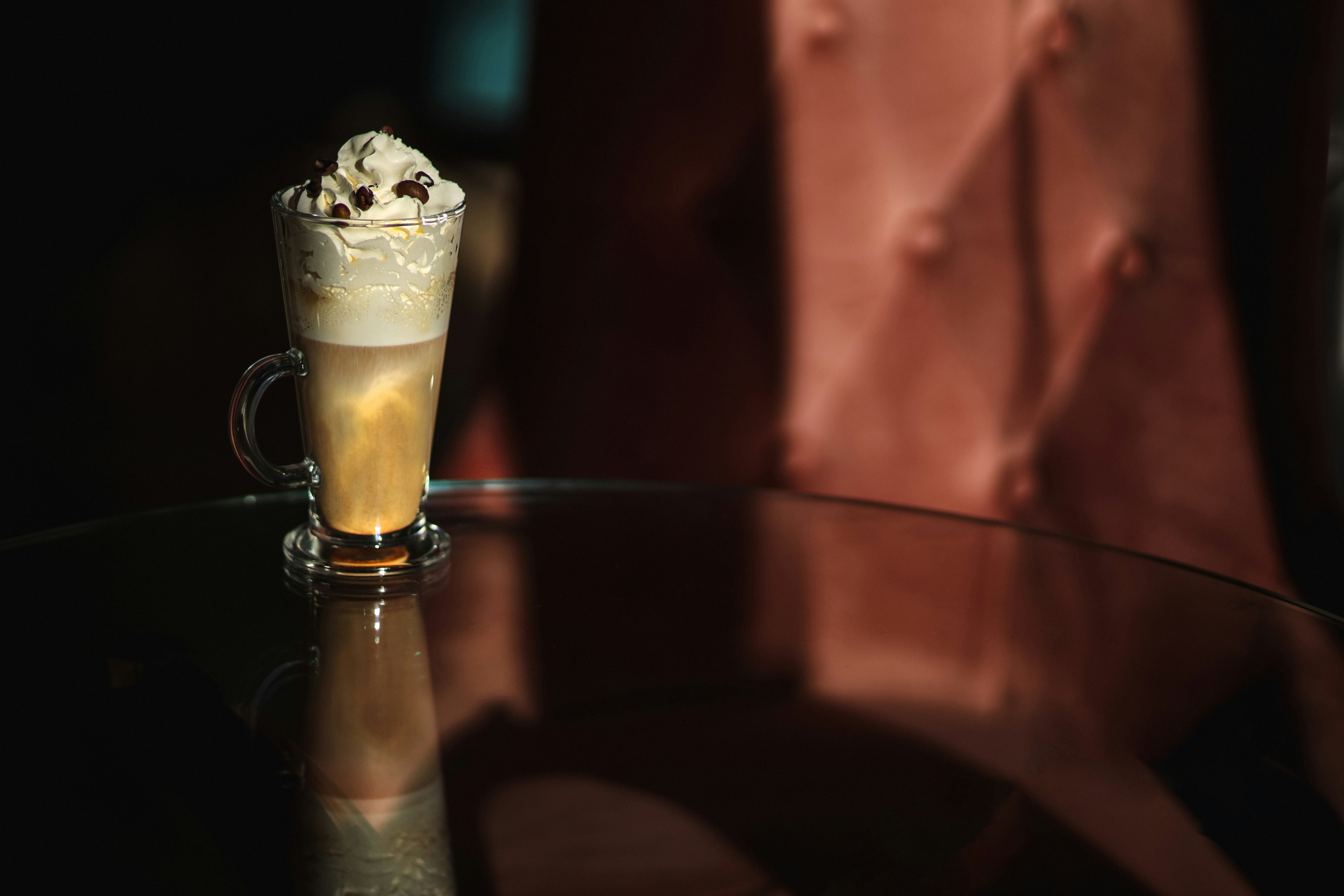 A glass table topped with a cup of coffee