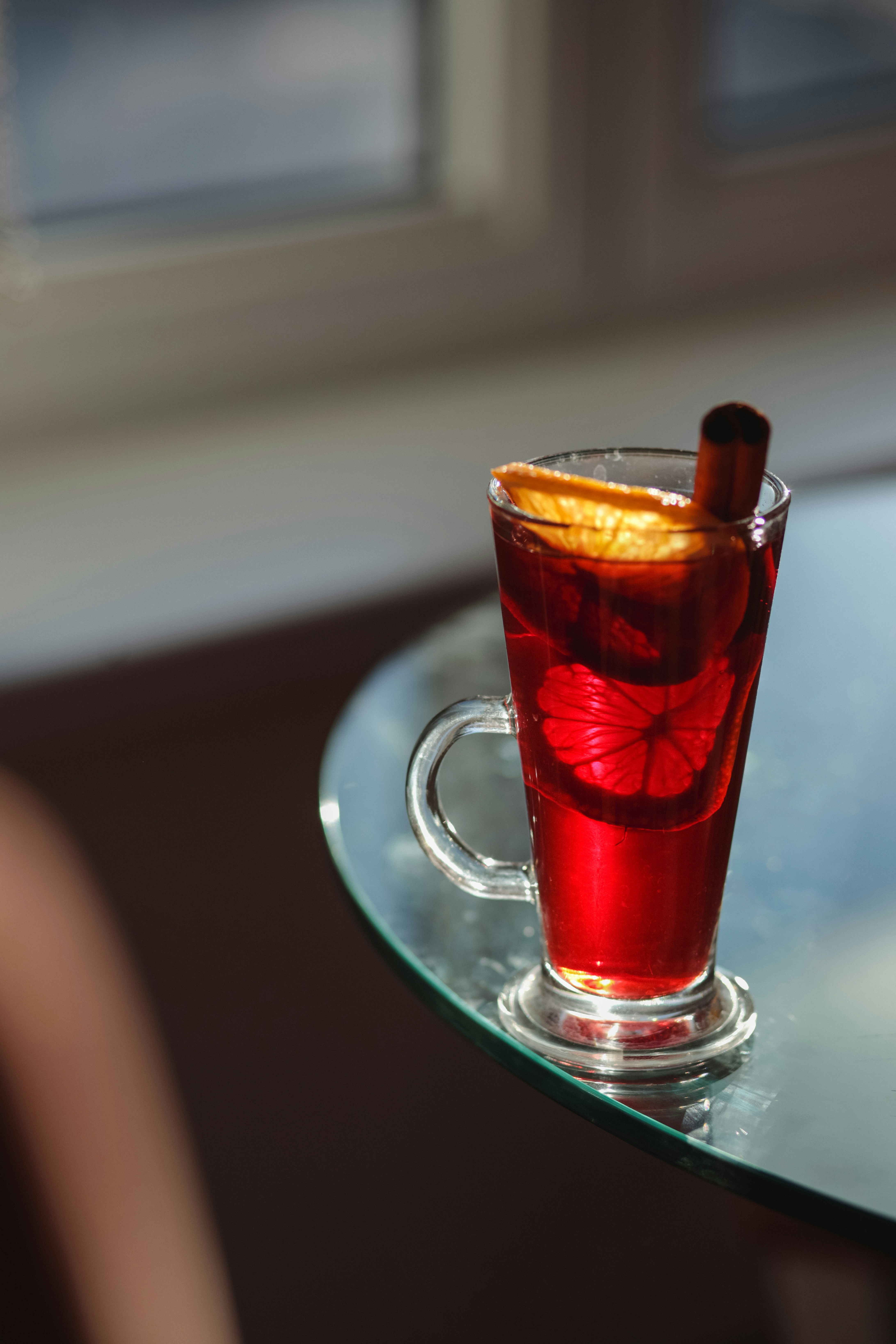 A red drink sitting on top of a glass table