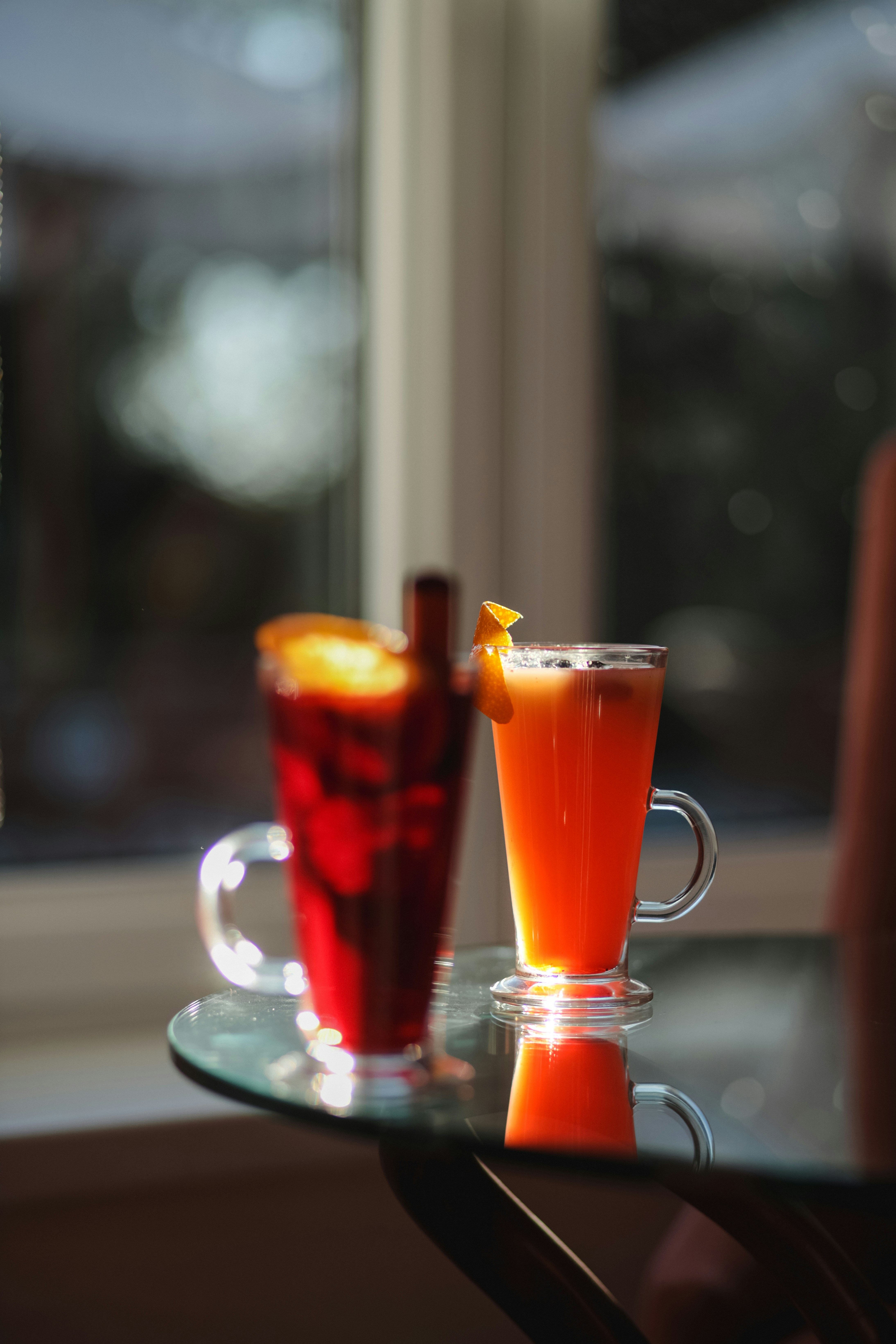 A couple of drinks sitting on top of a glass table