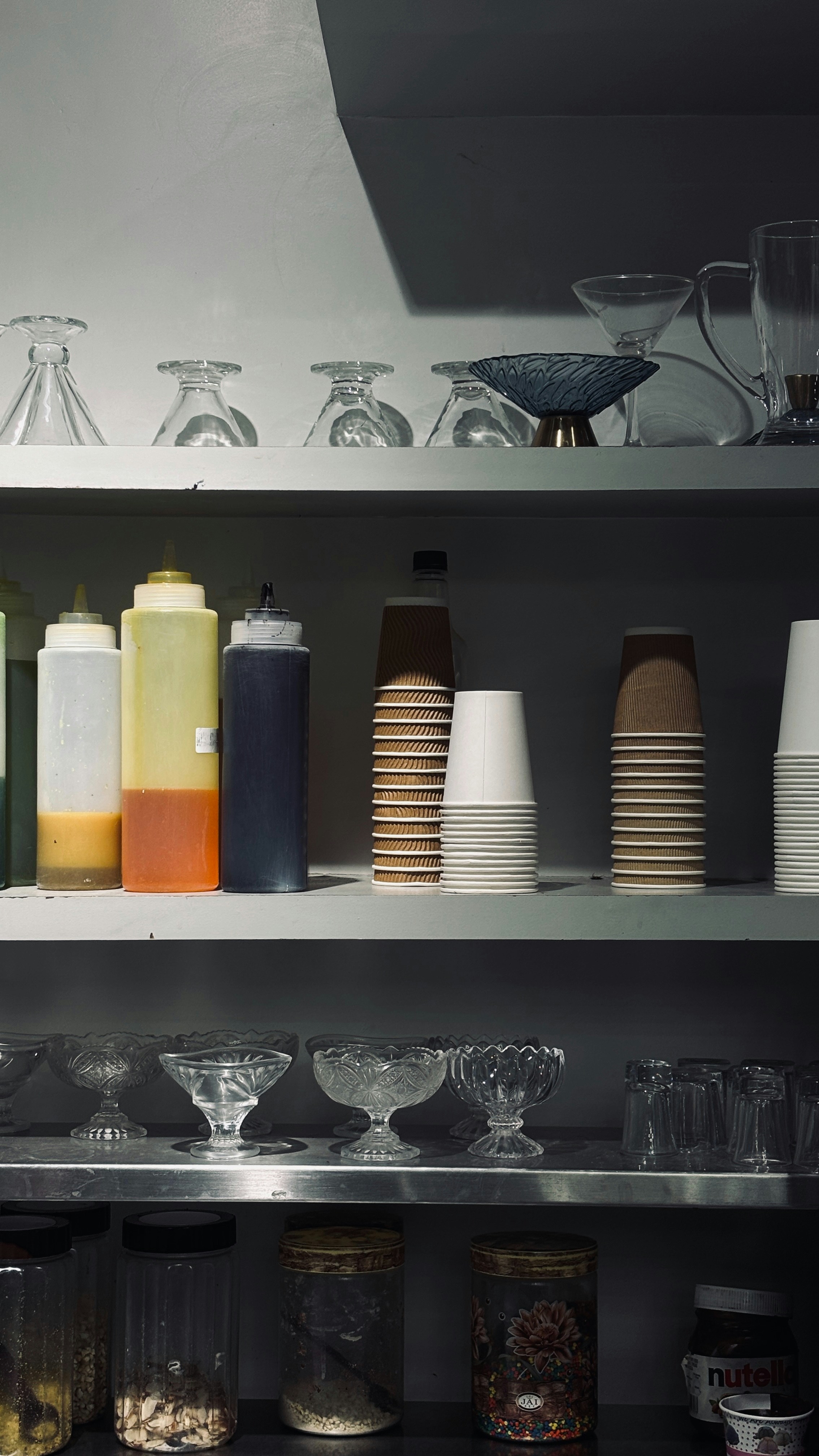 A shelf filled with lots of bottles and glasses