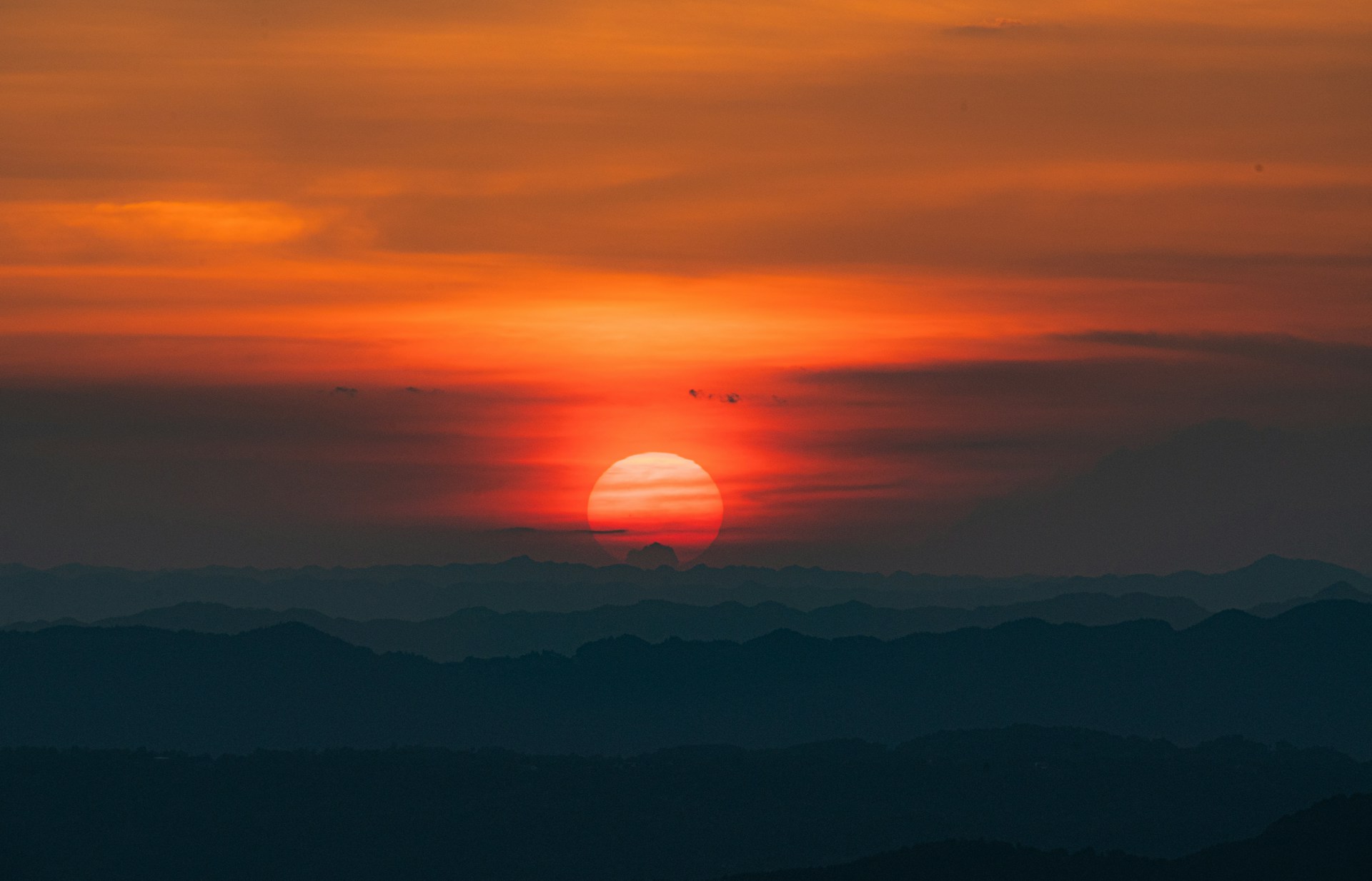 The sun is setting over a mountain range