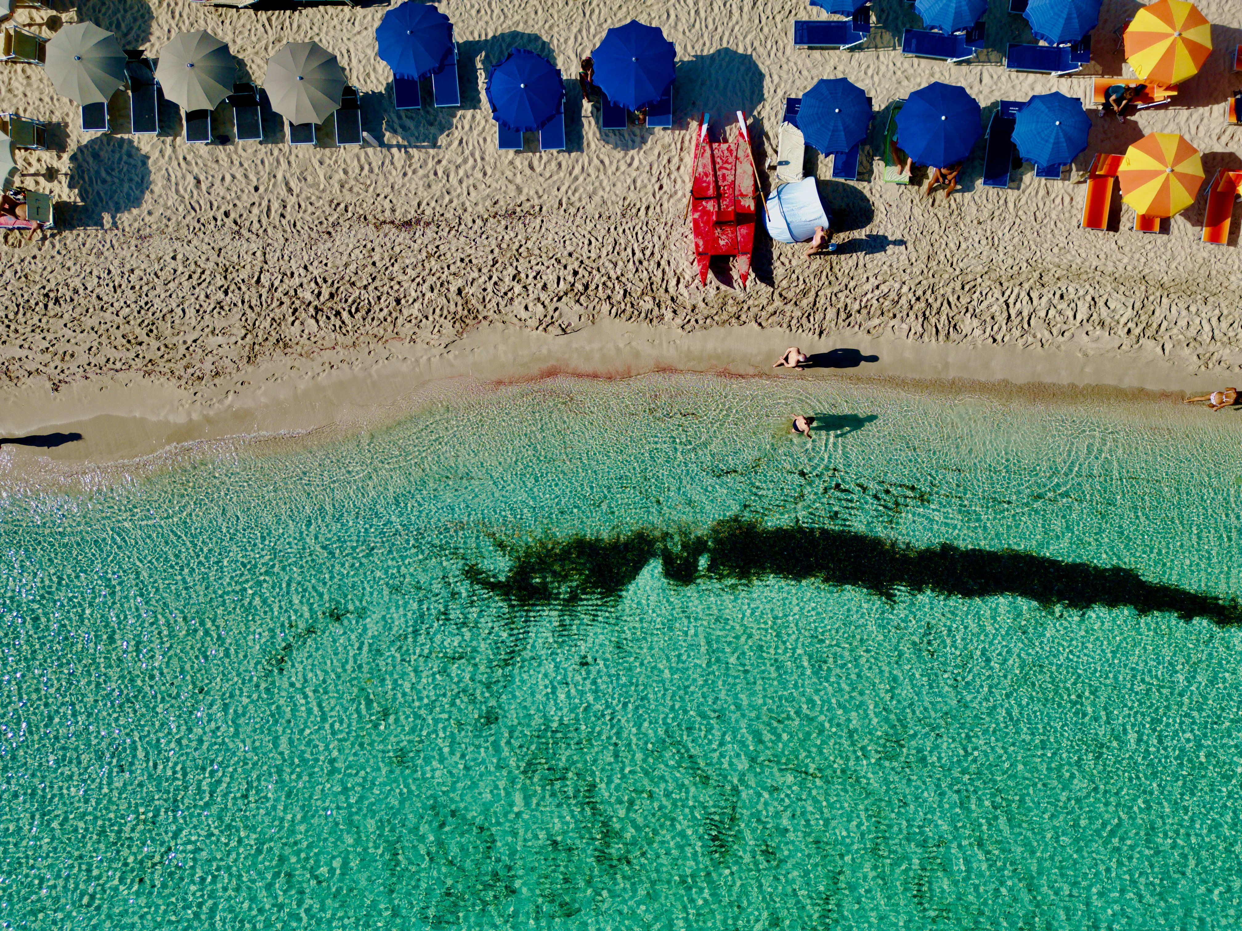 An aerial view of a beach with umbrellas and chairs