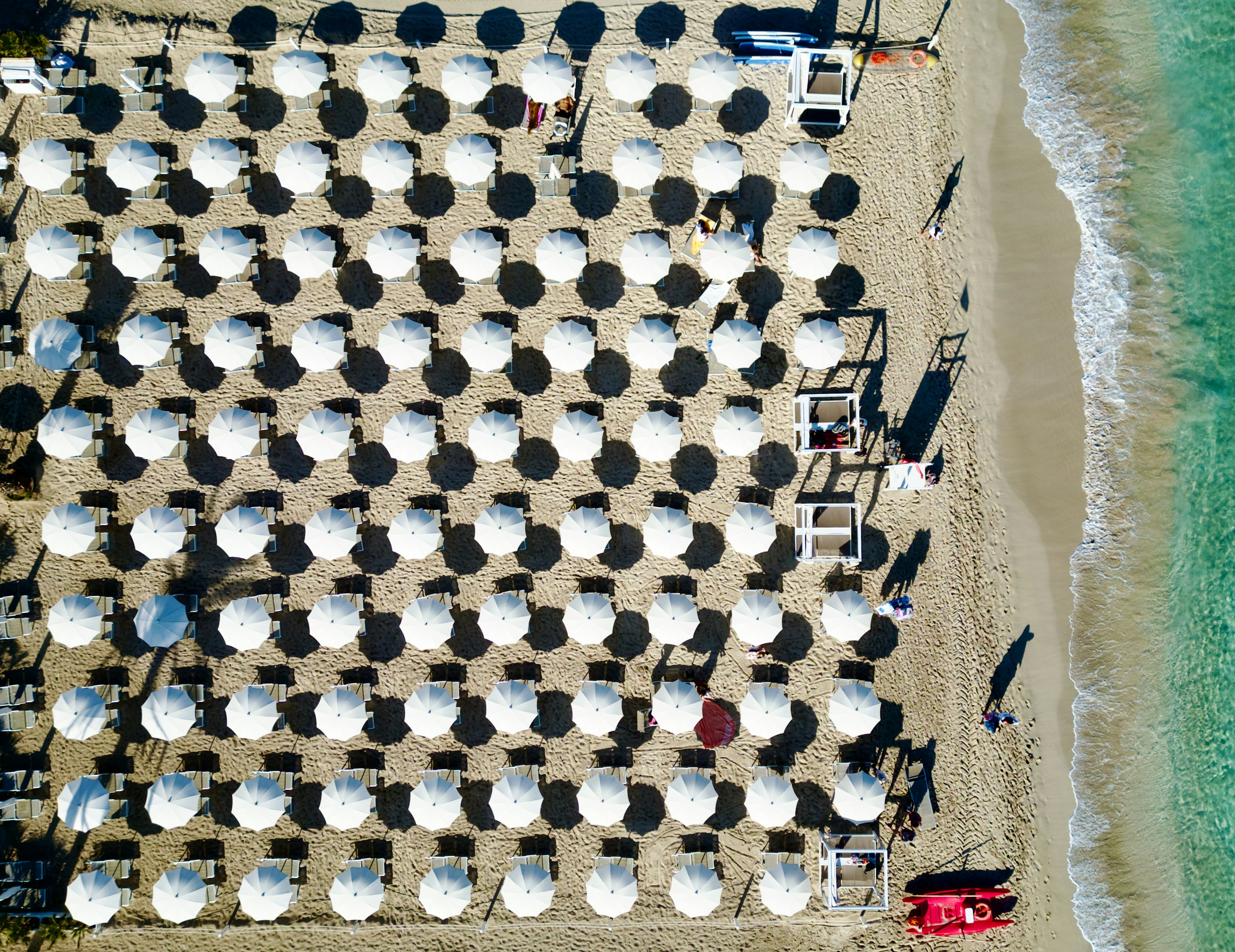 Foto aérea de playa española con hamacas y sombrillas en temporada alta