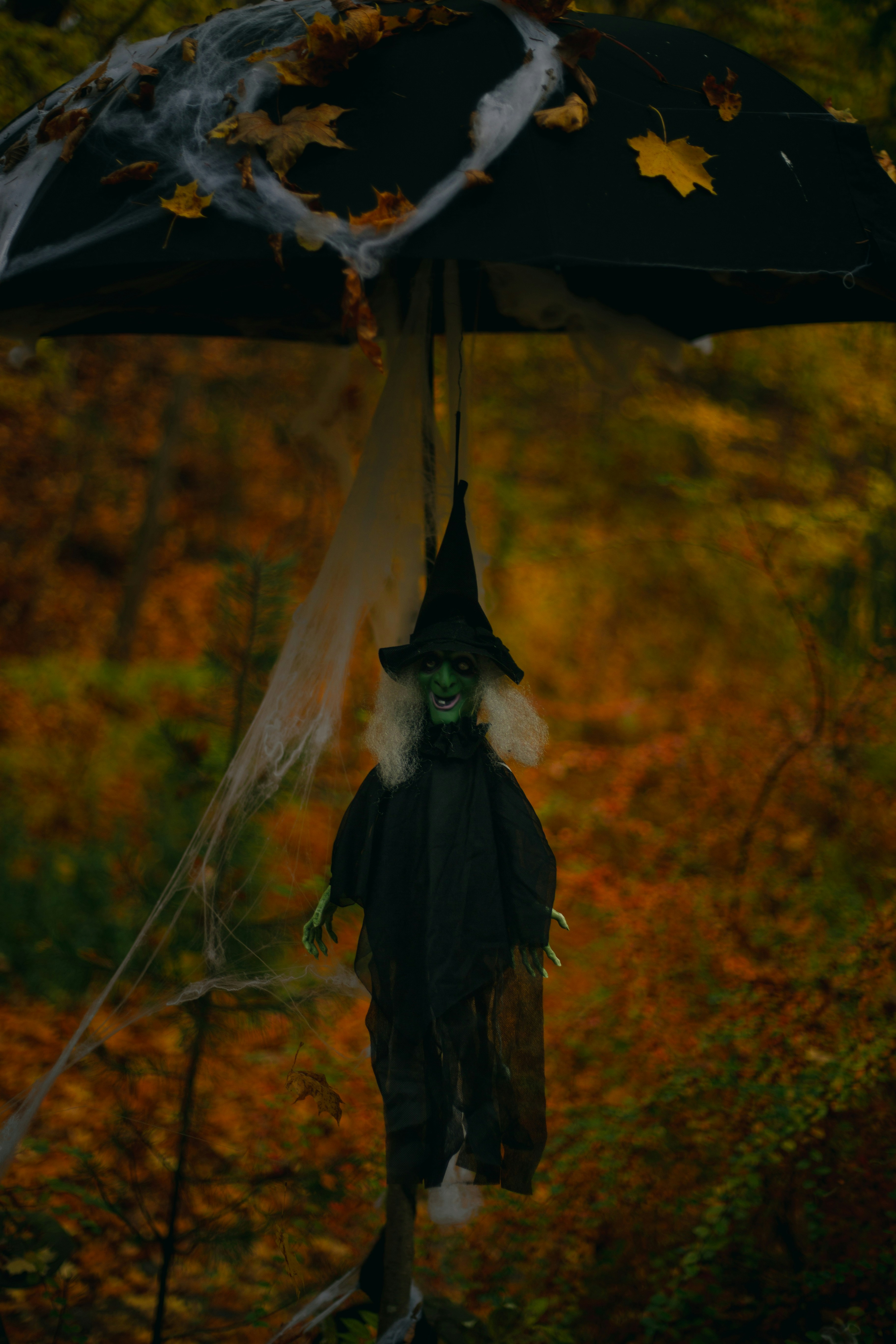 Un ombrello in bianco e nero con un costume da strega appeso