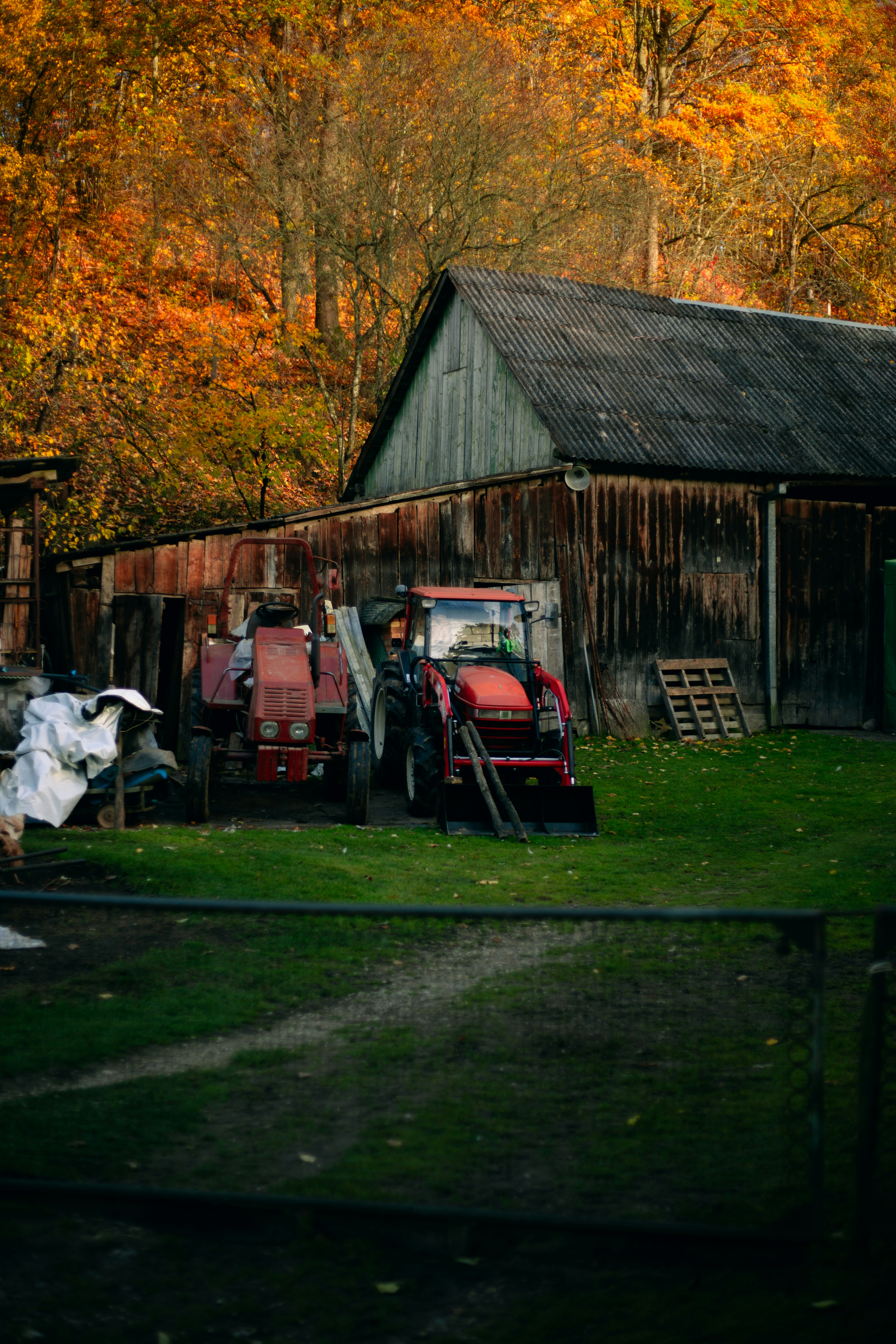 Un fienile con un trattore parcheggiato di fronte