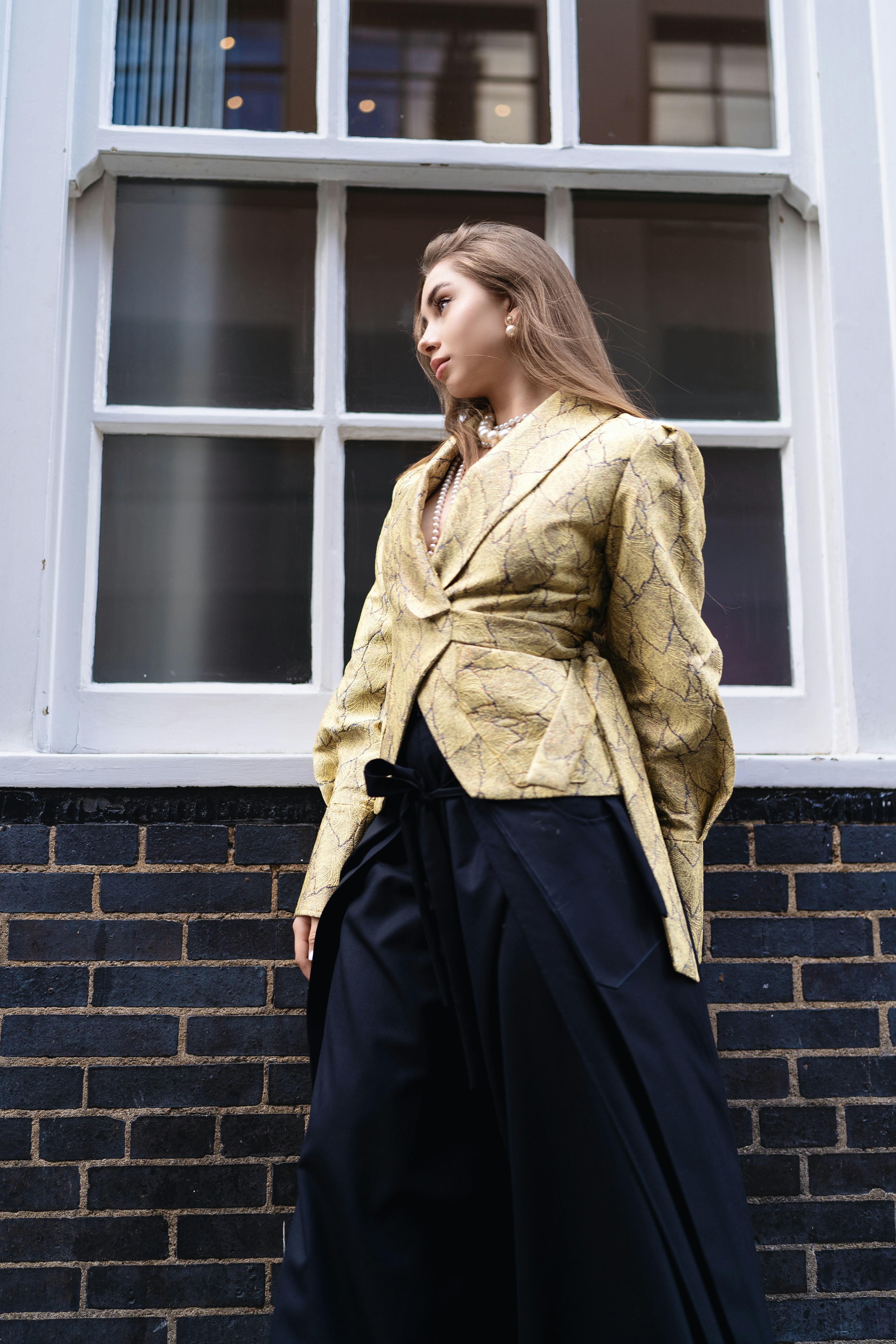 A woman standing in front of a brick wall