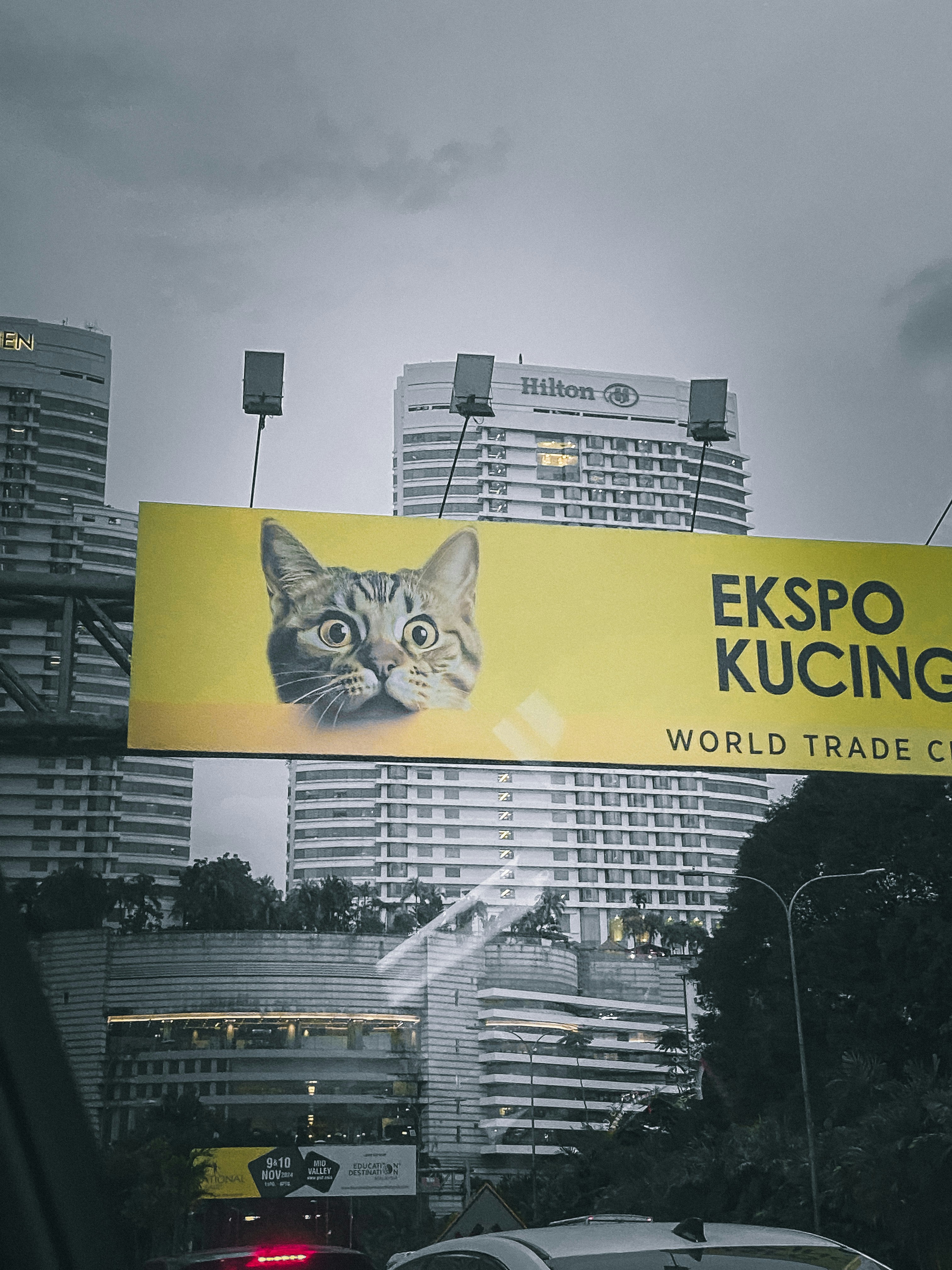 A yellow sign that says esspo kuching on the side of a road