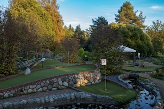 A golf course surrounded by trees and water