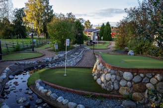 A golf course with a small pond in the middle of it