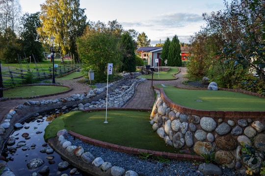 A golf course with a small pond in the middle of it